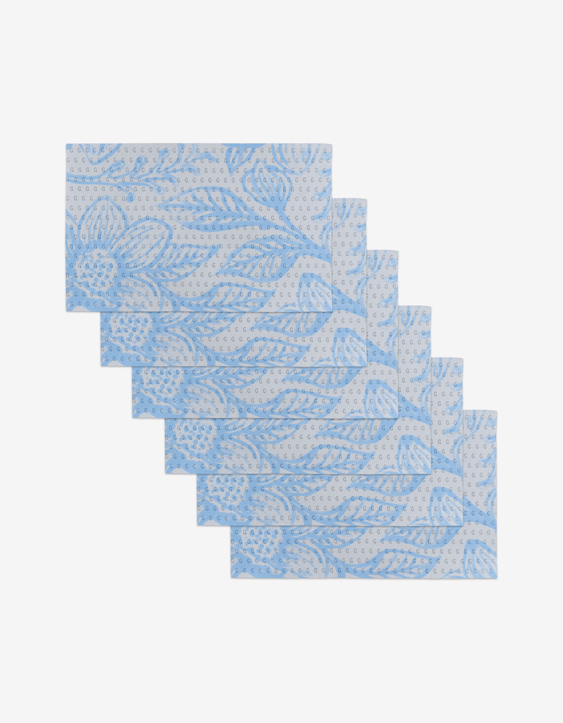 Six Something Blue reusable napkins by GEOMETRY, featuring a light blue floral and leaf pattern, are stacked on a white background—an eco-friendly alternative to disposable paper towels.