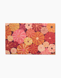 The Spicy Pumpkins mat by Rebecca Bobko showcases a vibrant floral pattern in pink, orange, red, and yellow on white. Use as eco-friendly kitchen towels or reusable paper towels for a cheerful touch—no more wasteful paper towels.