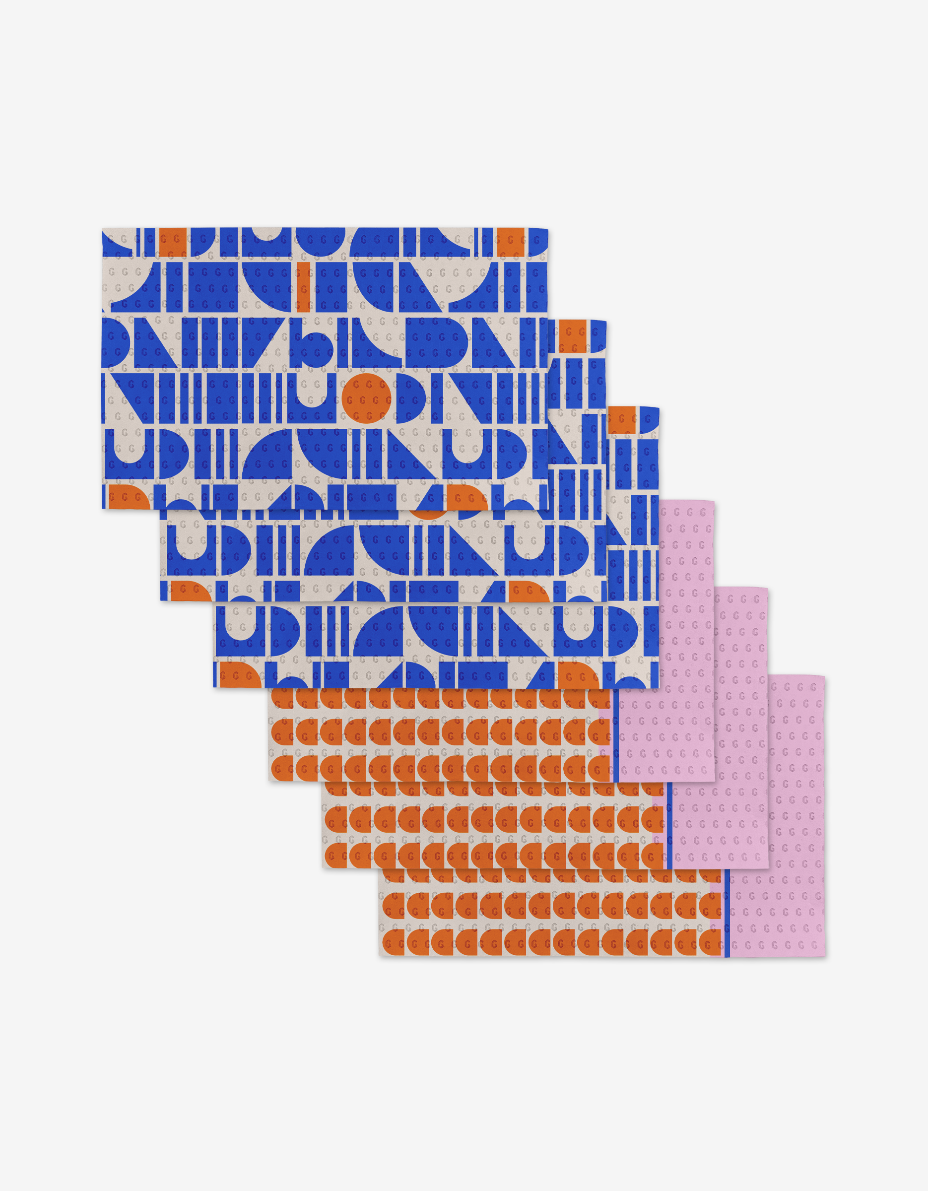 Six rectangular Sun Beam Harmony towels by Happy Hemera, featuring bold geometric patterns, are fanned out: three blue and gray on top, followed by two orange and gray, with a pink dotted one at the bottom. Eco-friendly design.