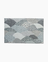 The Sweet Valley Hills Green rug by Hufton Studio features overlapping abstract hills in blue, grey, and white with small floral and leaf motifs—ideal for pairing with eco-friendly kitchen towels for a coordinated look.