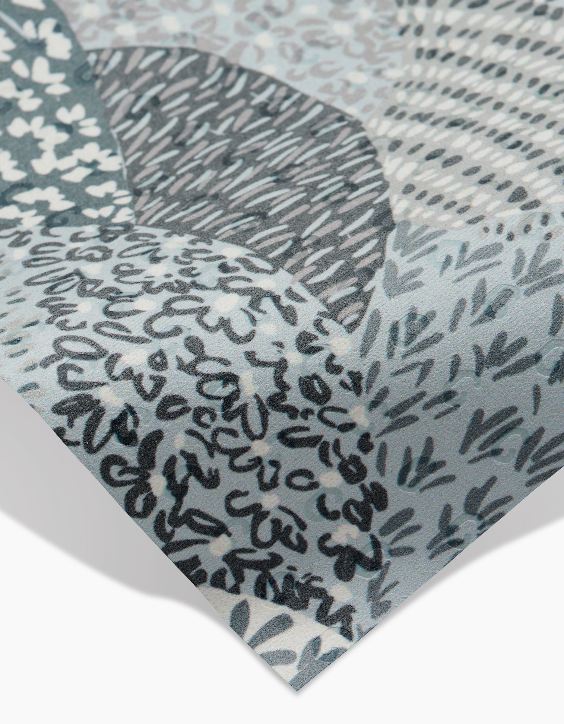 Close-up of a Sweet Valley Hills Green sheet by Hufton Studio, featuring abstract gray, blue, and white patterns with hand-drawn lines, dots, and leaf shapes. The corner is slightly lifted—ideal as an eco-friendly kitchen towel.