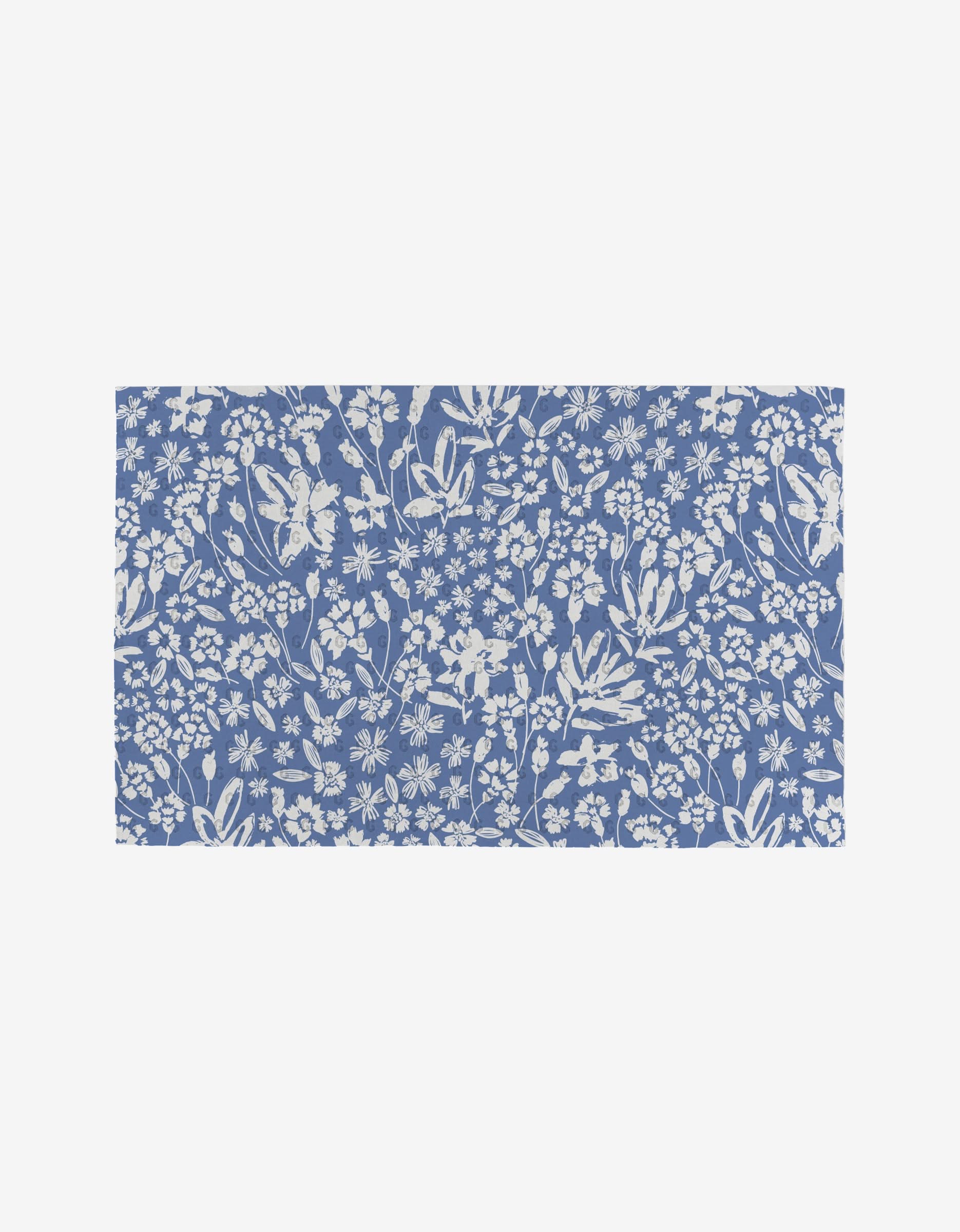 The Sweetie Floral mat by Hufton Studio features a blue background with white floral patterns, made from eco-friendly recycled materials.