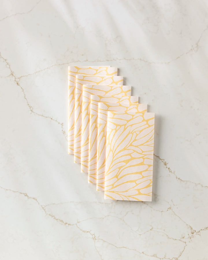 Seven "Tenderhearted" cards by GEOMETRY, featuring a yellow and white abstract feather pattern, are fanned out on a subtly veined light marble surface.