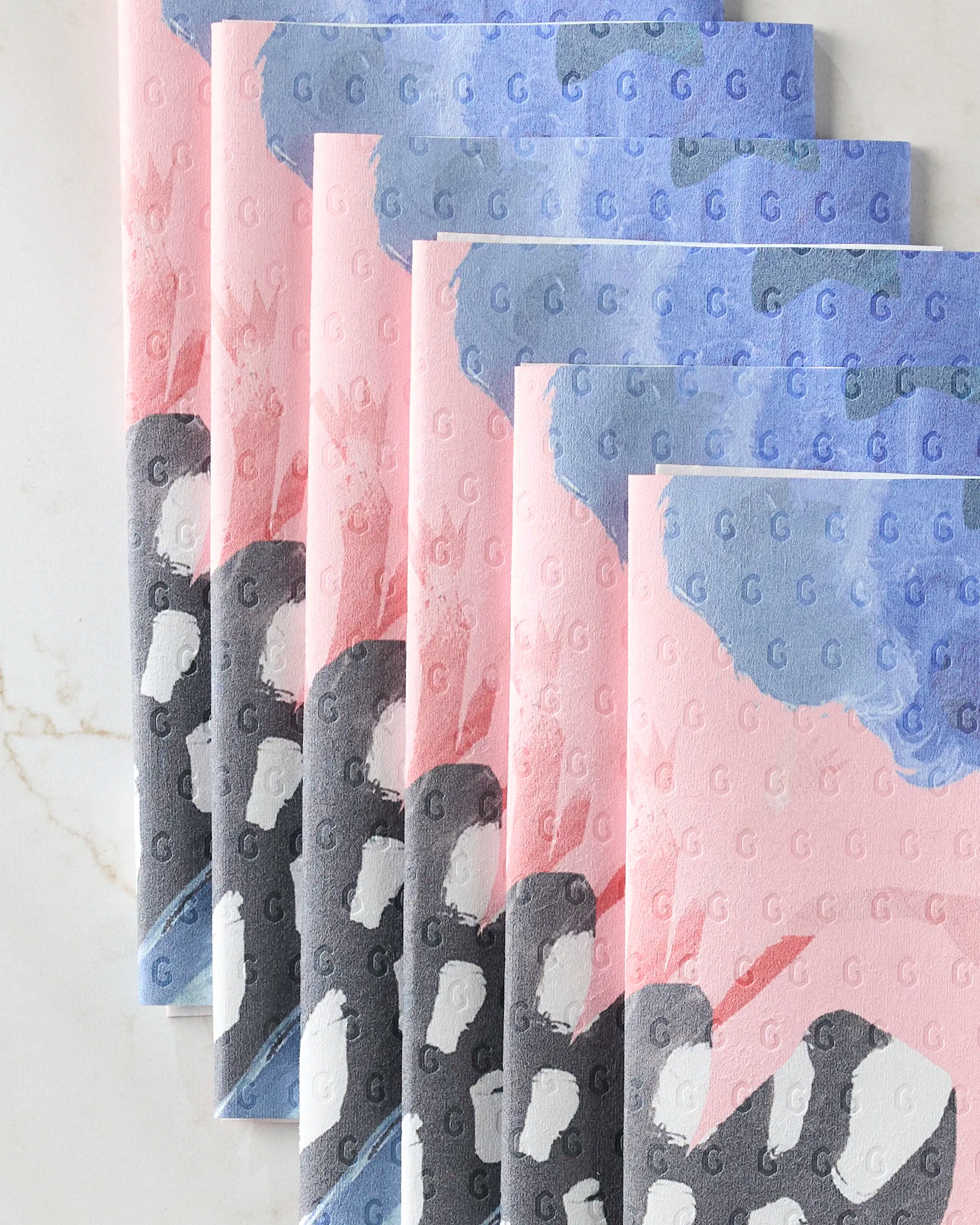Thinking Of You by GEOMETRY is a set of seven eco-friendly folded paper towels decorated with black and white penguins, gray backgrounds, touches of pink and blue, and scattered “G” letters.