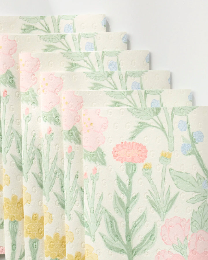 Five "Wildflowers in Bloom" eco-friendly paper towels by Jasmine Blooms Designs, featuring pastel pink, yellow, and blue florals with green stems and leaves, are fanned out in a slightly overlapping arrangement on a white background.