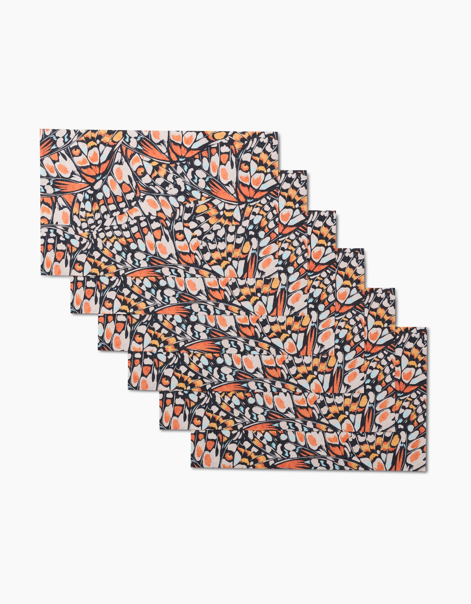 Six Wings in the Wind rectangular placemats by GEOMETRY, featuring colorful orange, white, and navy abstract shapes, are arranged in a fanned stack. Made from economical, eco-friendly post-consumer recycled materials.