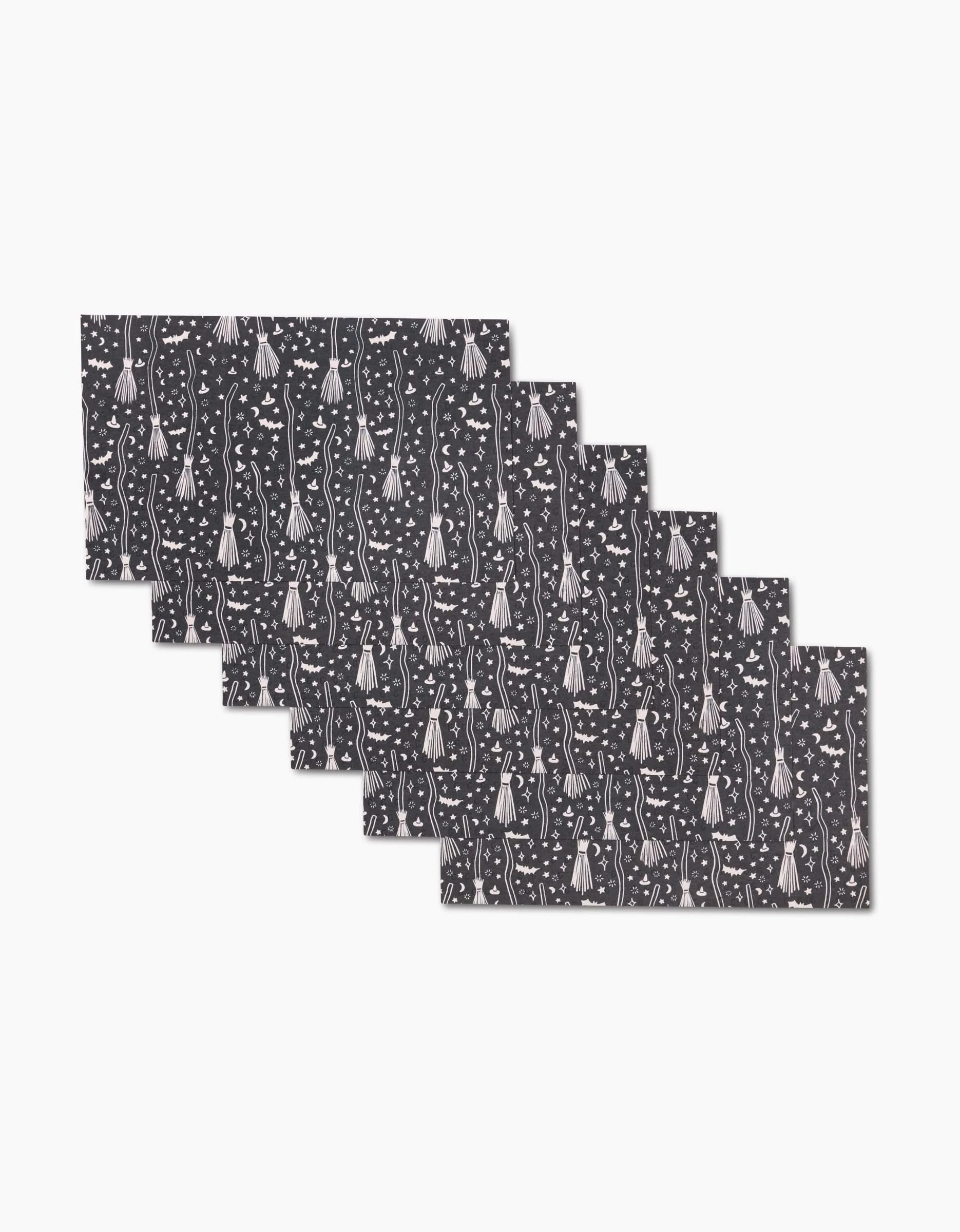Six identical rectangular Witches Broom placemats by Kayla Ann feature a dark design with white fish and aquatic plants, displayed in a slight fan on a white background—perfect for matching with eco-friendly kitchen towels.