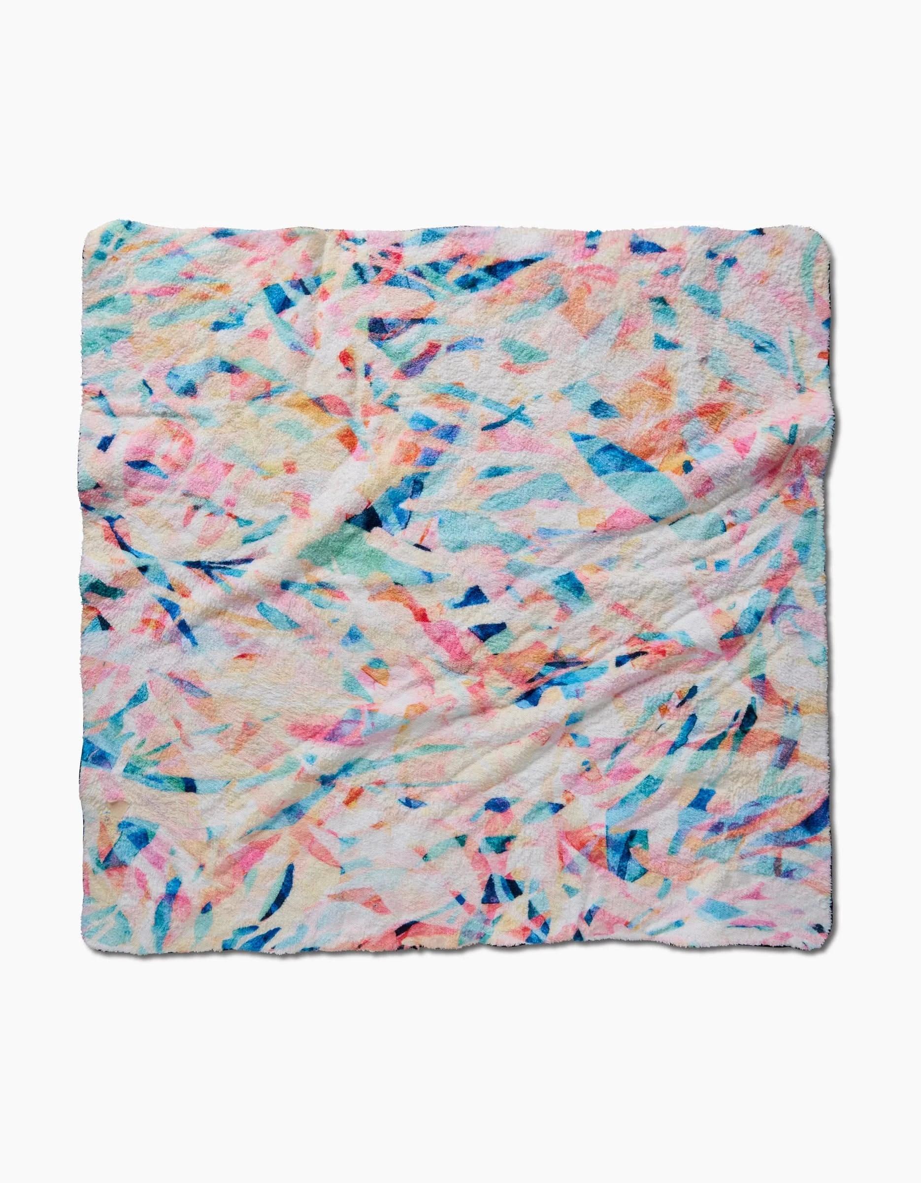 The Rachel Parker Abstract Jungle dog towel is a soft, square plush with a colorful abstract pattern—splashes of blue, pink, orange, and yellow on white. Ultra-absorbent and slightly textured for comfort.