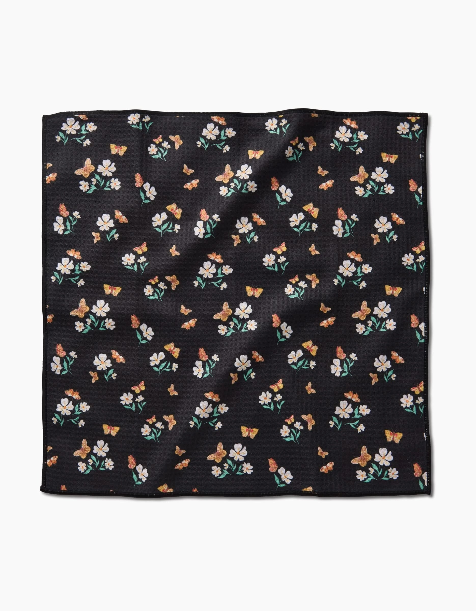 The Danelys Sidron Butterfly Garden is a square black Paw Towel made from ultra-absorbent Geoweave fabric, featuring a pattern of small colorful flowers and butterflies on its slightly textured surface.
