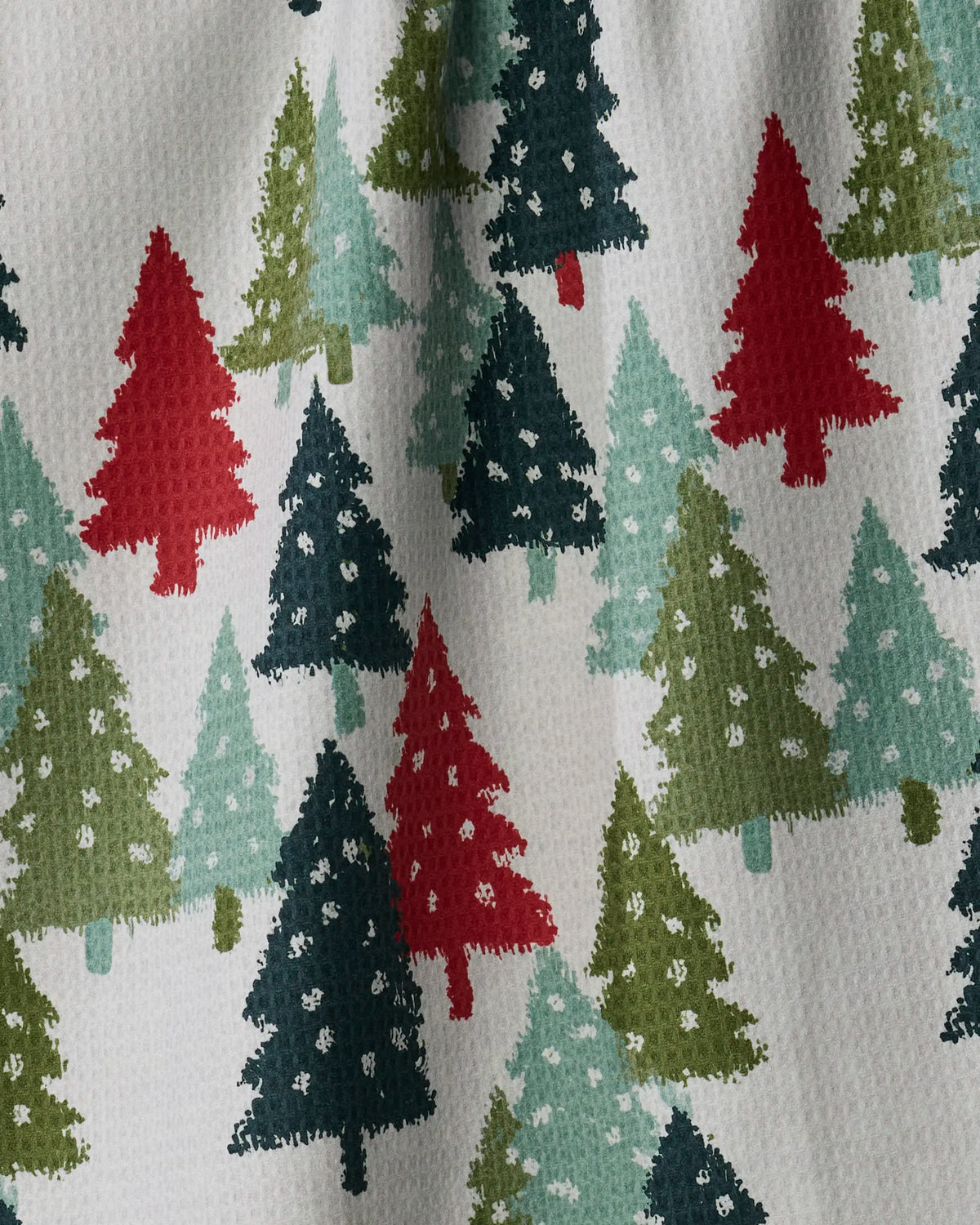 Pine Parade by Geometry is an absorbent, quick-drying towel that combines festive style with functionality. Featuring a patterned design of green, red, and teal Christmas trees on a white background with subtle shadows and surface texture, it’s perfect for tackling holiday kitchen tasks.