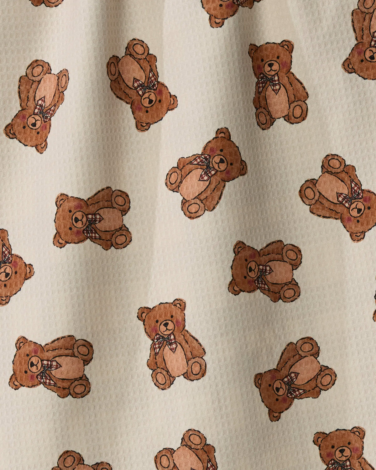 Introducing “Plaid Teddy” by Geometry: This double-sided tea towel is crafted from recycled kitchen towel material, offering excellent absorbency and quick-drying functionality. The design features adorable brown teddy bears adorned with red and blue plaid bows, playfully posed at various angles atop a light beige textured background—combining delightful charm with eco-friendly practicality.