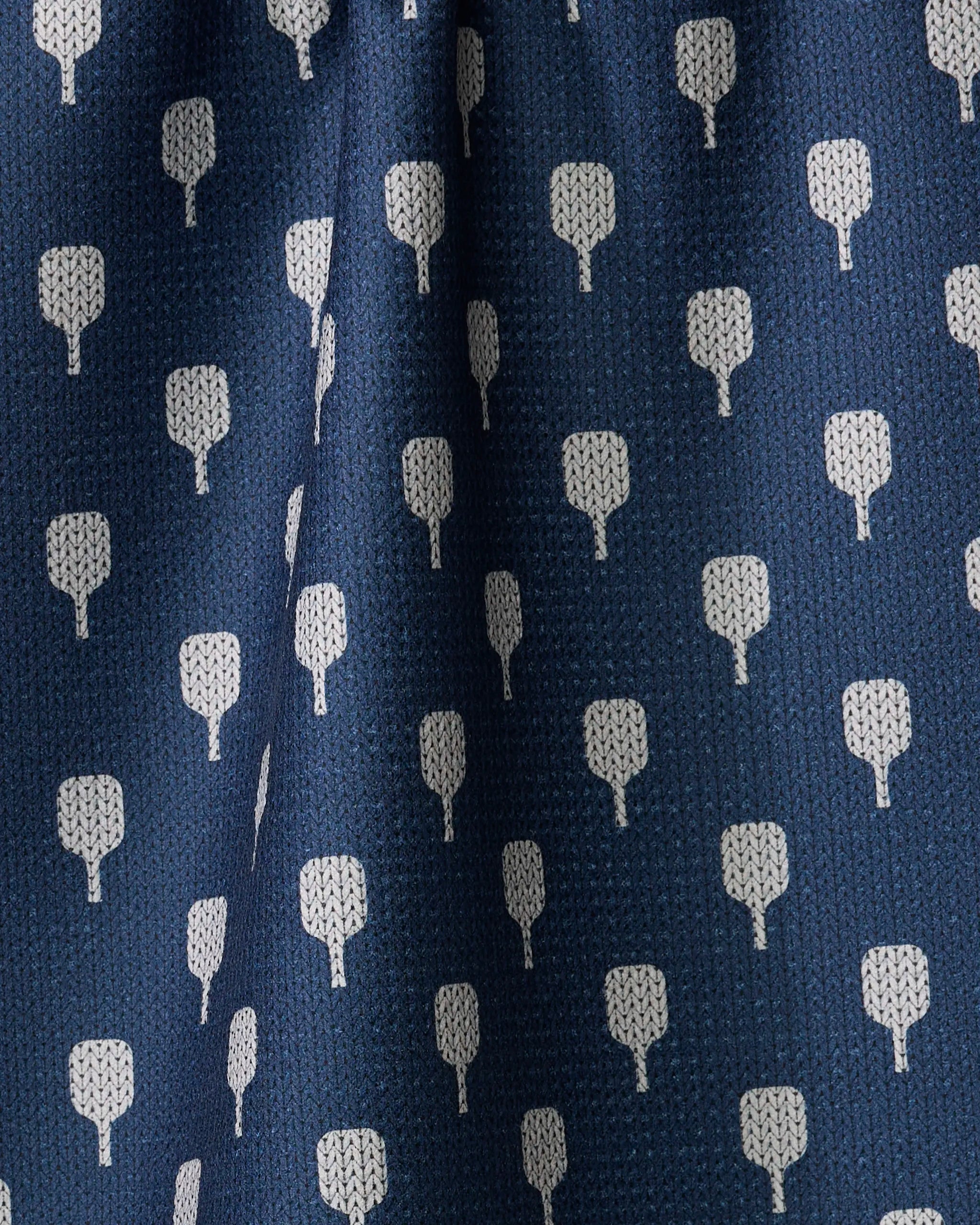 Close-up of The Modern Dad's Mr. Pickler tea towel in blue, featuring a repeating pattern of small white tree-like shapes. Made from recycled materials, the fabric has subtle folds and a textured surface.
