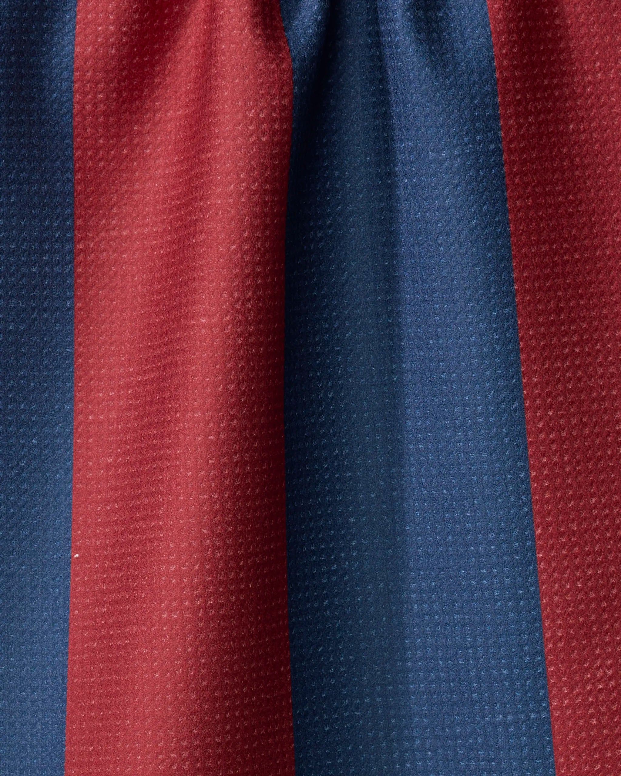 Close-up of The Modern Dad’s Mr. Rugby tea towel with red and blue stripes, made from recycled materials. Its textured surface and soft folds showcase a quick-drying design.