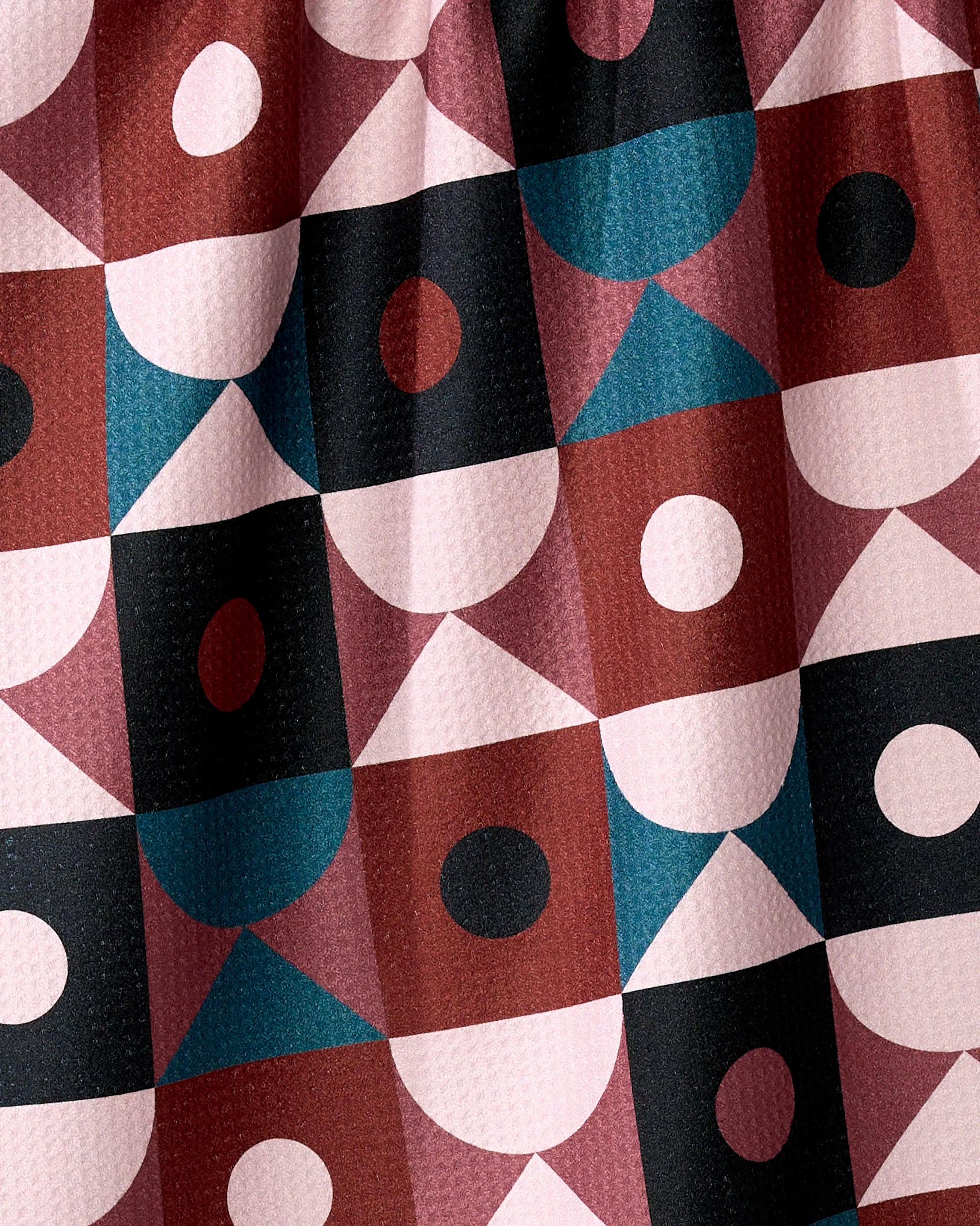 The Abstract Retro tea towel by Jennifer Bouron features a repeating geometric design with squares, circles, triangles, and ovals in burgundy, blush pink, teal, black, and white on absorbent recycled fabric.