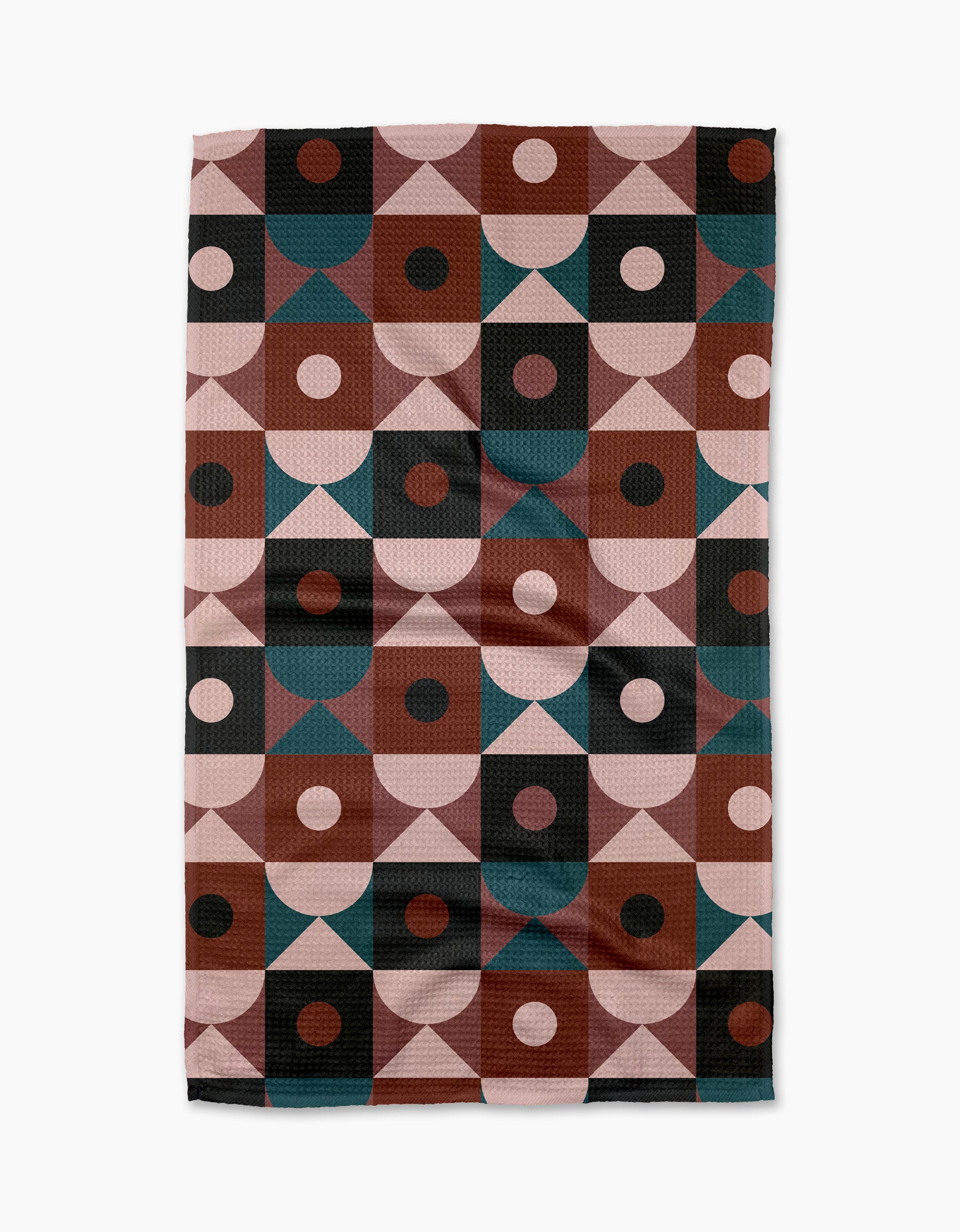 The Abstract Retro kitchen tea towel by Jennifer Bouron features a mid-century modern geometric pattern in pink, brown, black, and teal. Made from recycled materials, it adds a vibrant, eco-friendly touch to your space.