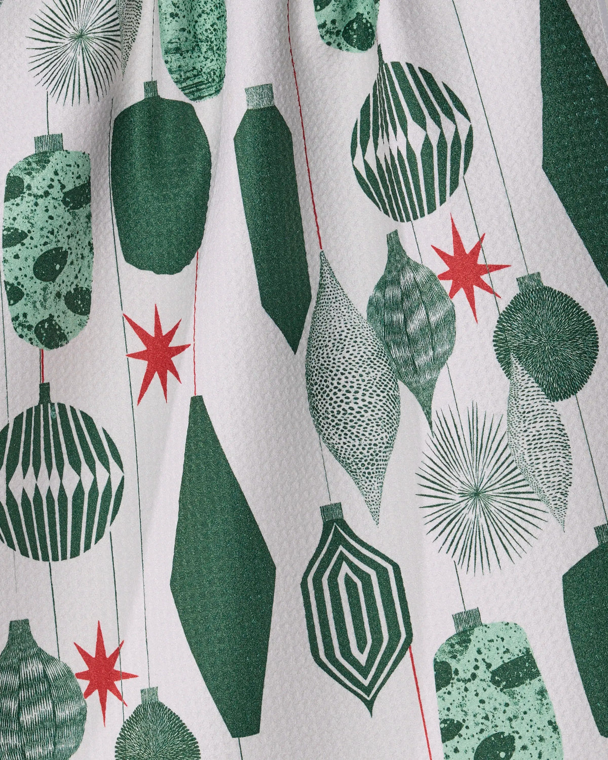 Introducing Alpine Revelry by Geometry: This eco-friendly tea towel showcases a festive holiday motif with green and white geometric ornaments and red starbursts on a crisp white background. Crafted from quick-drying recycled materials, Alpine Revelry brings sustainable style and practical functionality to your seasonal kitchen decor.