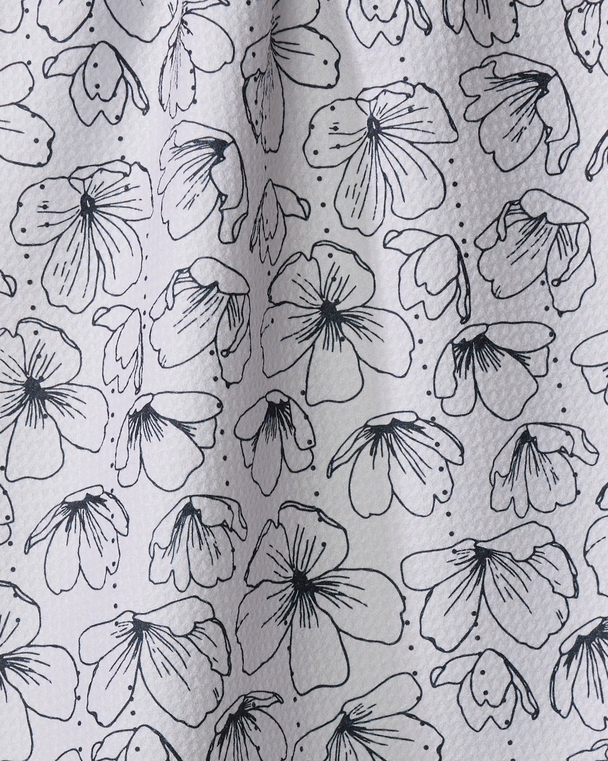 Always Blooming" by Rosa Kichline features abstract black floral line drawings with petals and dots, scattered across an ultra-absorbent towel made from recycled kitchen towel material on a textured white background.
