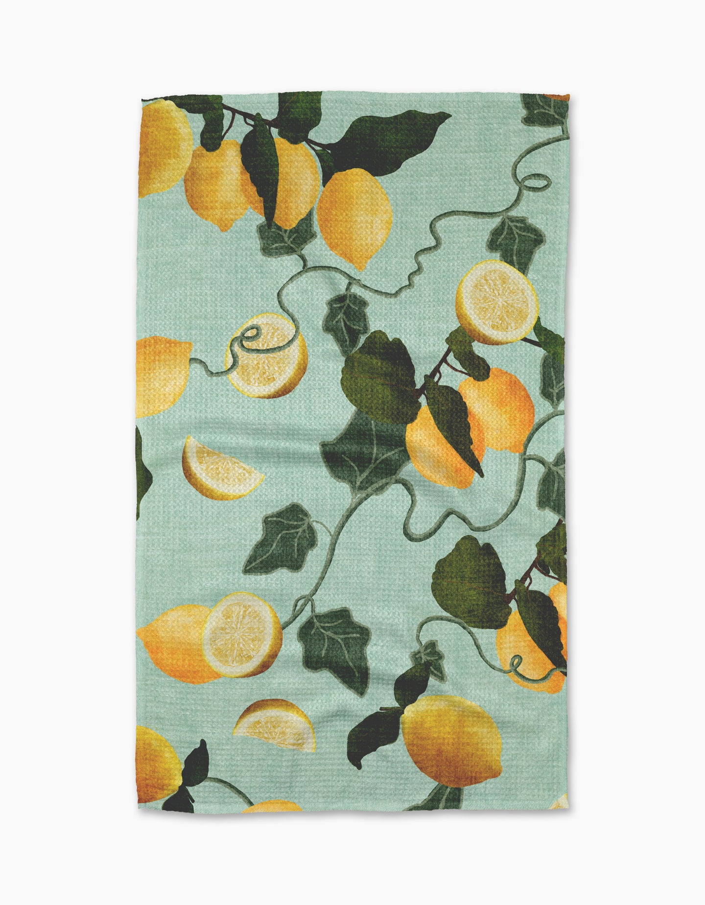 The Pascale Dilger Amalfi Lemons tea towel features a light blue background with ultra-absorbent fabric, decorated with a pattern of whole lemons, lemon halves, and dark green leaves on trailing vines.