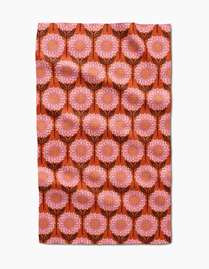 The Amy MacCready Amber tea towel is made from recycled materials and features large pink and orange flowers with black stems on deep orange, forming a symmetrical, ultra-absorbent surface.