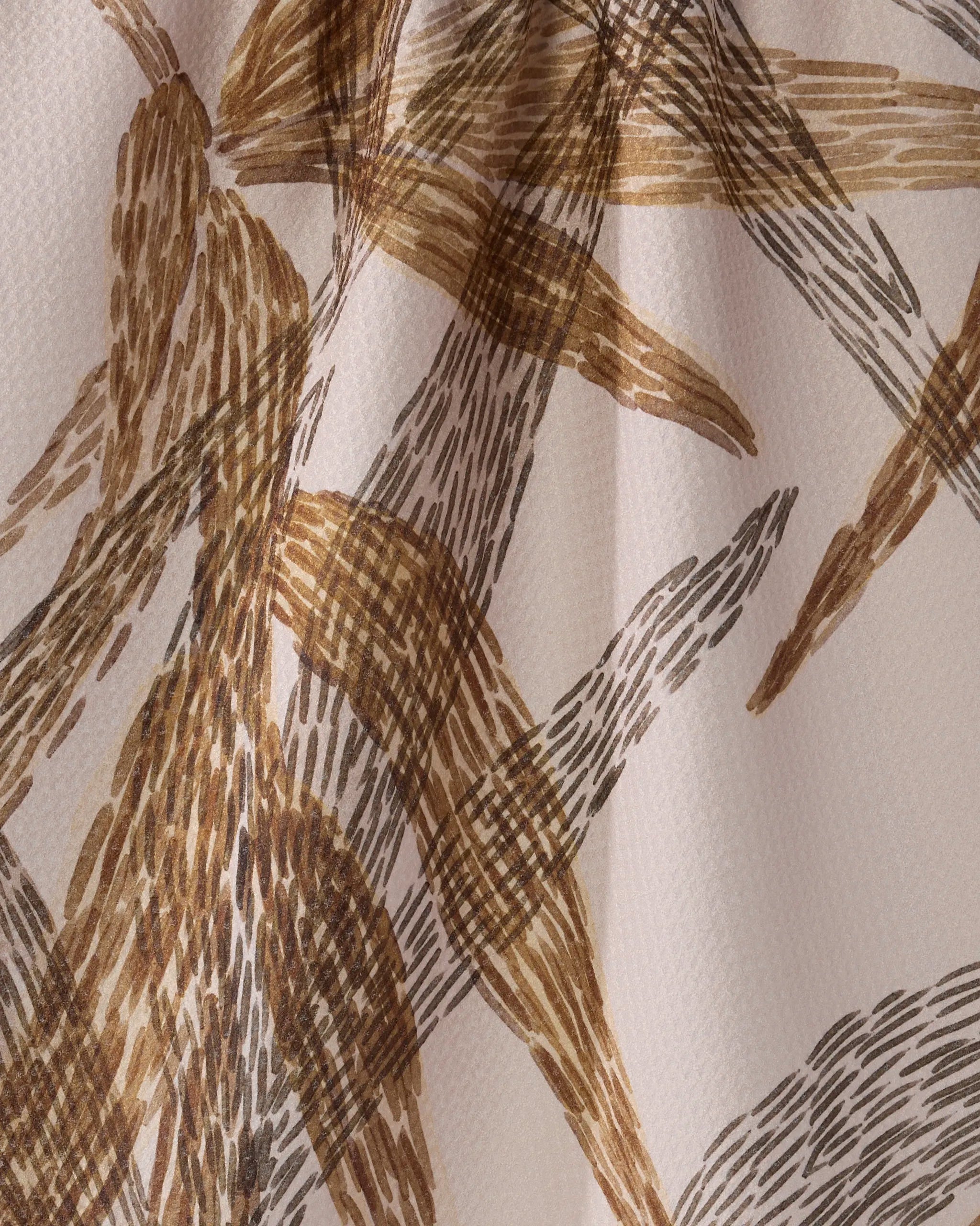 Close-up of Geometry's "Amber Wildflower" recycled kitchen towel, featuring beige fabric with an abstract pattern of brown and tan brushstrokes. The quick-drying towel is slightly folded for added depth and a textured, organic look.
