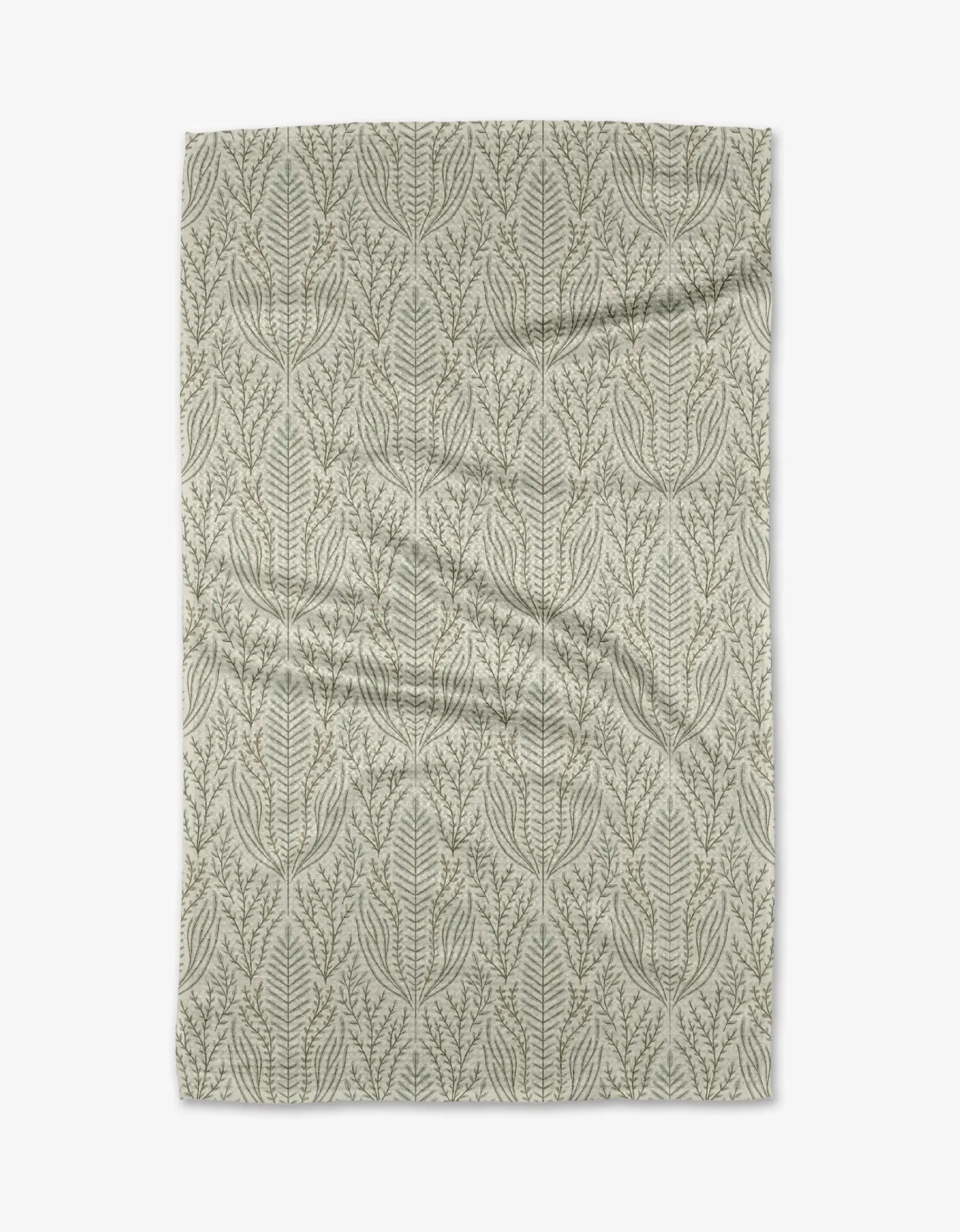 The Amberlin blanket by Amy MacCready is a light gray throw made from recycled materials, featuring a repeating leafy botanical pattern in a darker gray, shown flat on a white background.