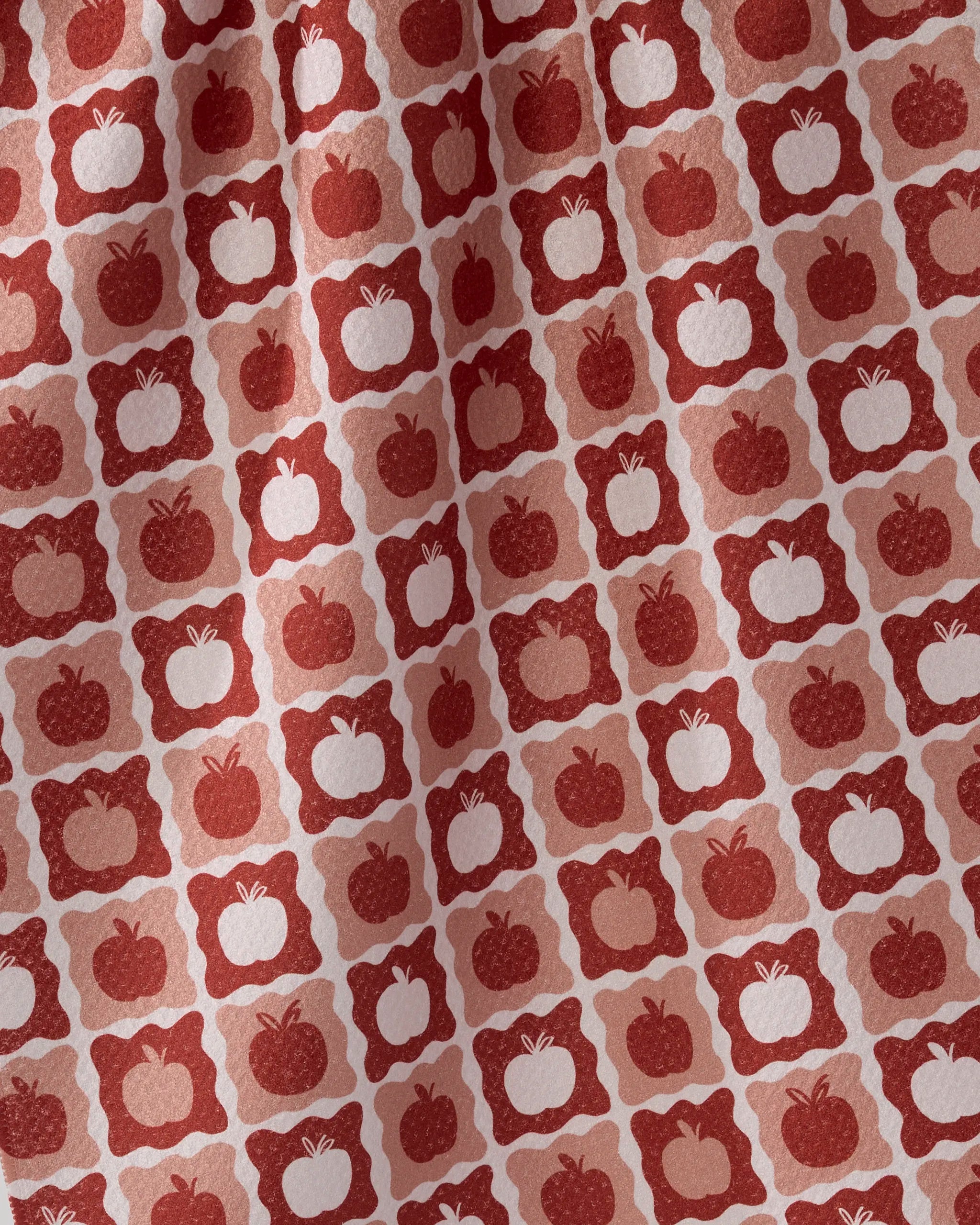 The Geometry Apple Quilt tea towel features a red and white pattern of squares, each with a simple apple motif. Subtle shade variations add texture, making it an ultra-absorbent and stylish addition to any kitchen.
