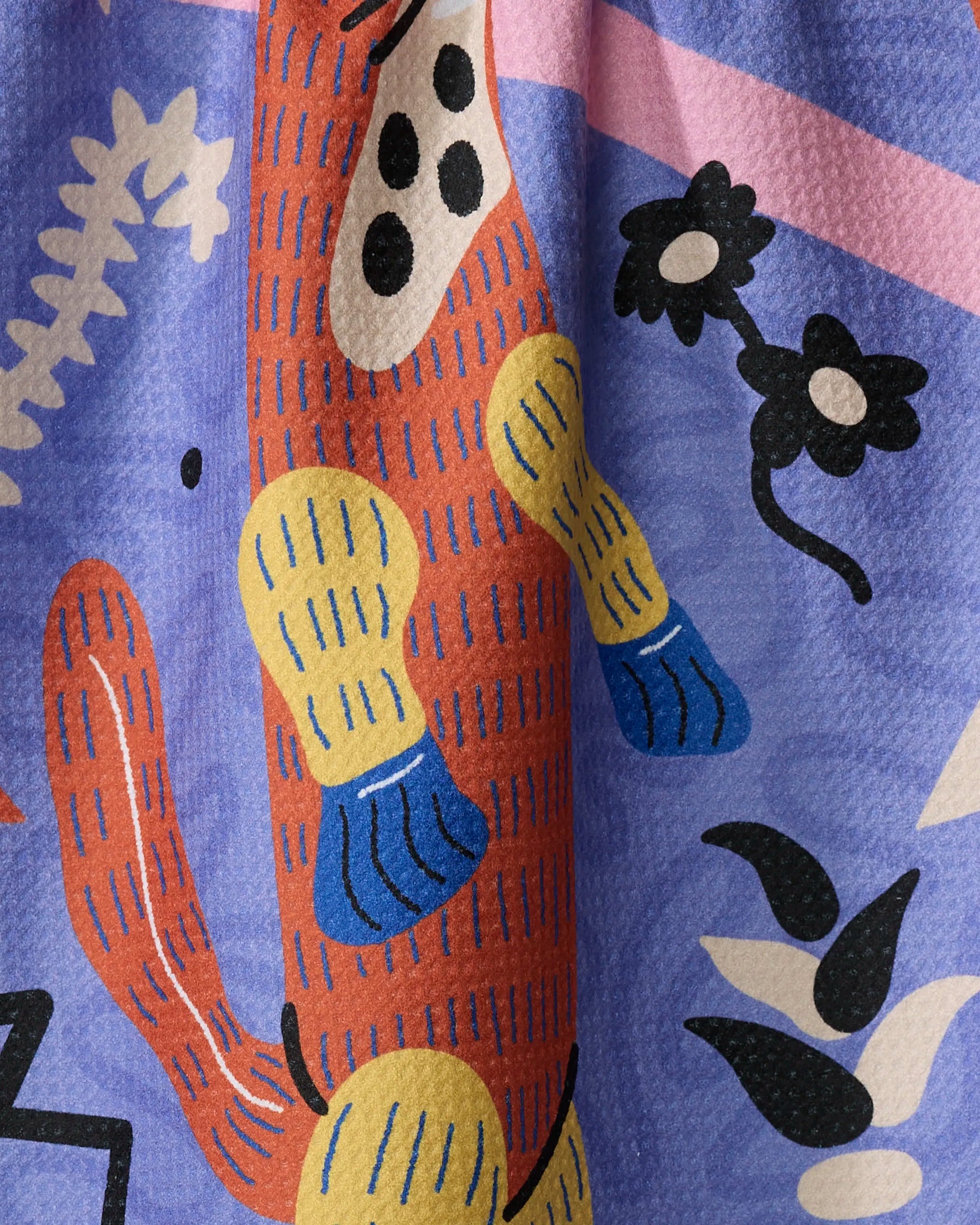 The "Ariranha" tea towel by Camila Leão features a colorful abstract design of a long orange creature with blue and yellow limbs on a purple background, accented by black, white, and pink geometric and floral shapes.