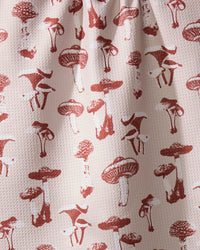 The Geometry Autumn Mushrooms tea towel features red mushroom illustrations on a textured white surface and is made from recycled materials.