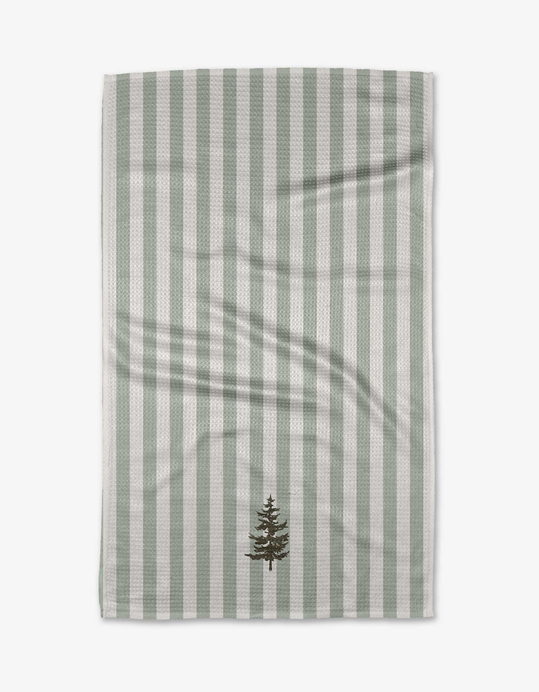 The Balsam kitchen towel by Kelsi Fullmer is made from recycled materials and features vertical light green and white stripes with a small, dark green embroidered evergreen tree near the bottom edge, shown on a white background.