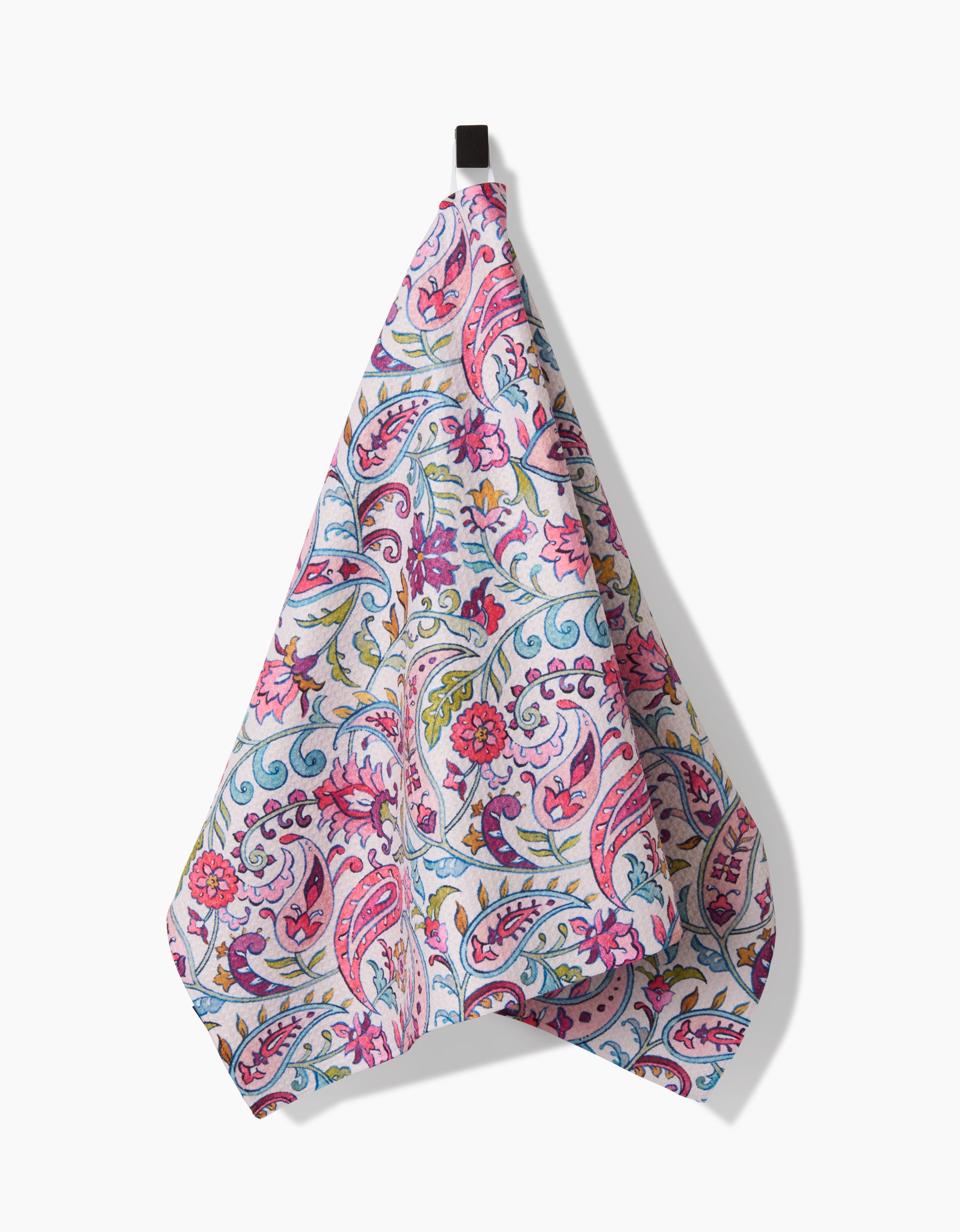 The Bazaar tea towel by Maayan Alper-Swan features a vibrant paisley and floral pattern in pink, purple, blue, and green, made from recycled materials and displayed hanging against a white background.