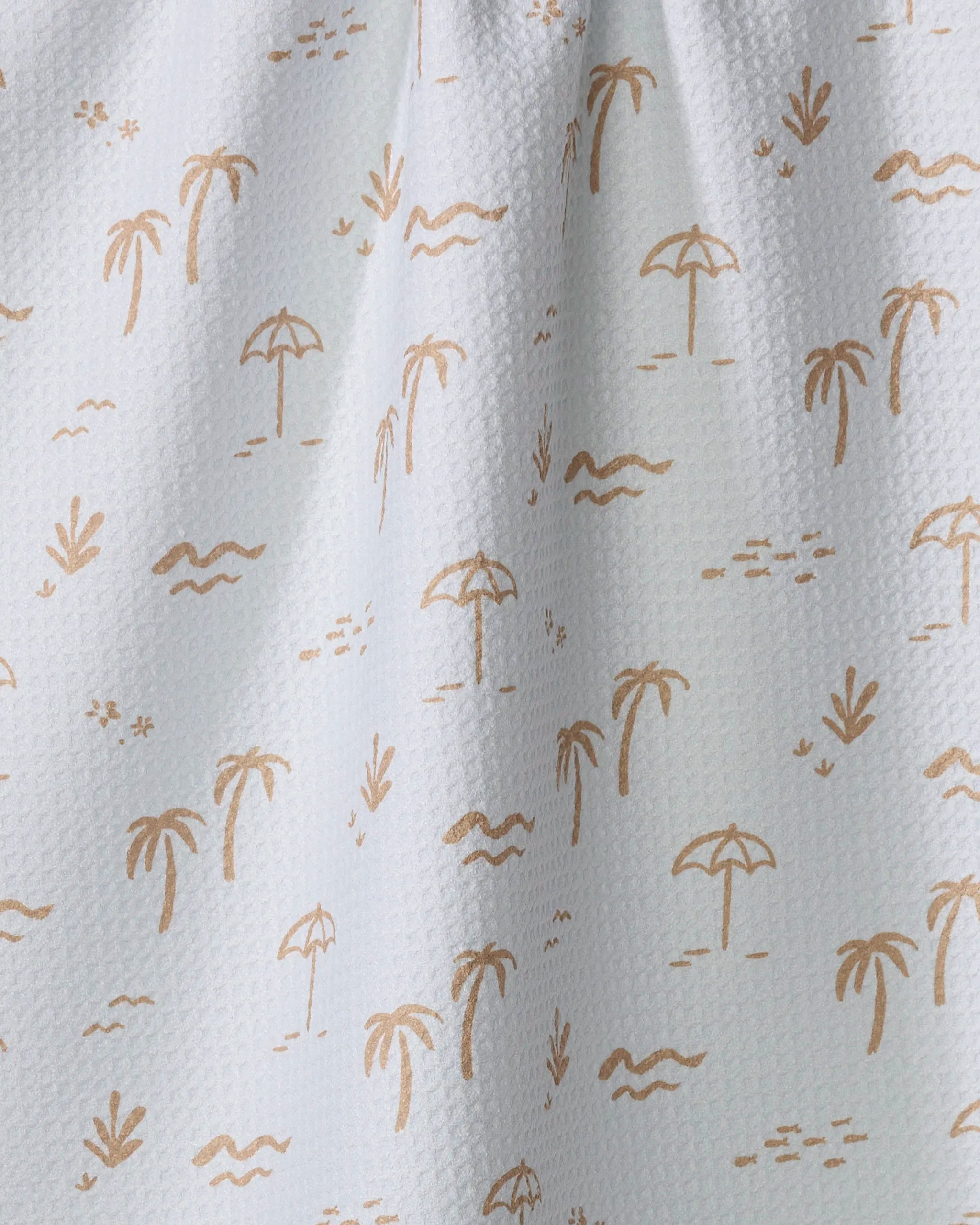 The "Beach" tea towel by Jen B. Peters features a white textured design with light brown palm trees, umbrellas, birds, waves, and grass—bringing a tropical beach vibe to your kitchen decor.