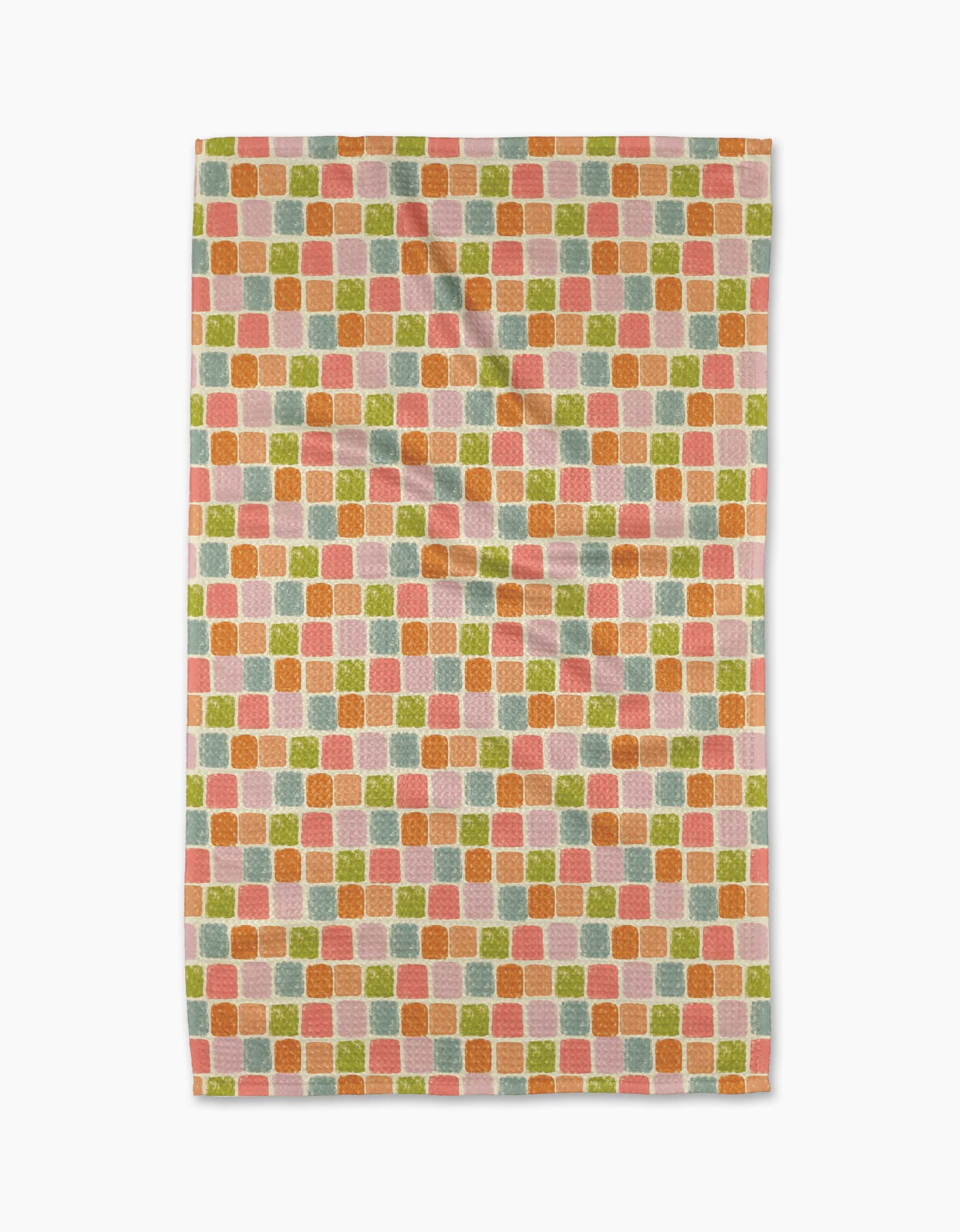 The Geometry Beachy Tile Tea Towel features an eco-friendly rectangular design with a repeating pattern of small textured squares in orange, pink, green, and pale yellow on white Geoweave fabric. Photographed with slight folds against a white background.