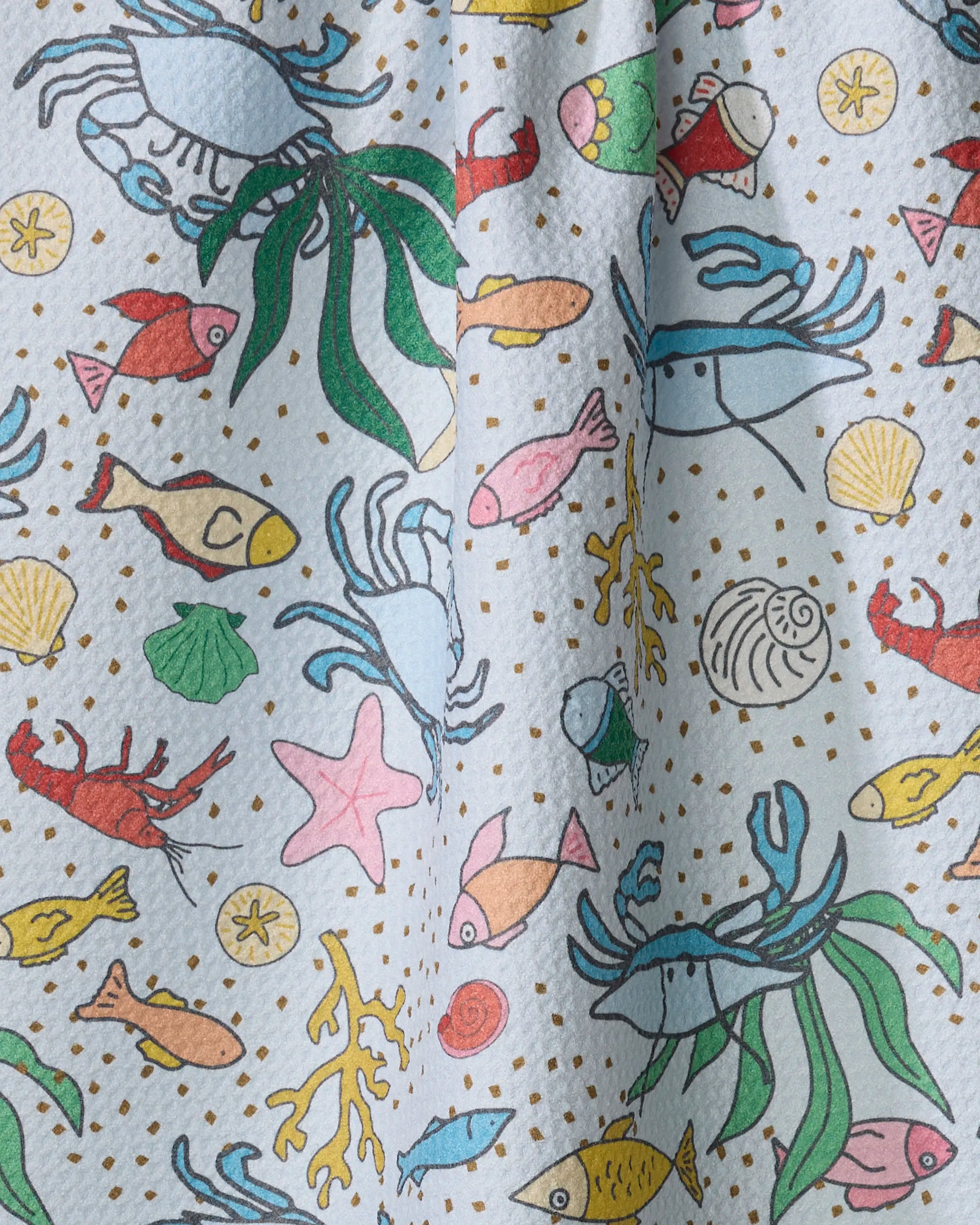 The "Beneath the Waves" tea towel by Mindfulnice features vibrant cartoon sea creatures on a light, dotted background. Quick-drying and made from recycled materials, it’s both eco-friendly and whimsical.