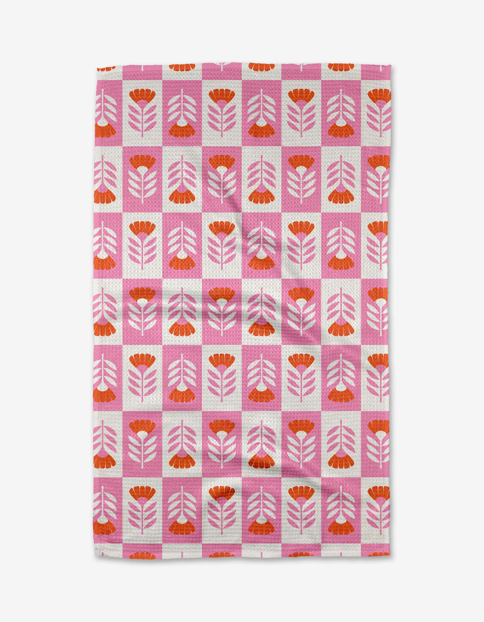 The Berry Flower Patch tea towel by Charlie Rowan Designs features a retro-inspired pink and red floral pattern with a pink grid on white. Made from ultra-absorbent recycled materials, it adds vibrant style to any kitchen.