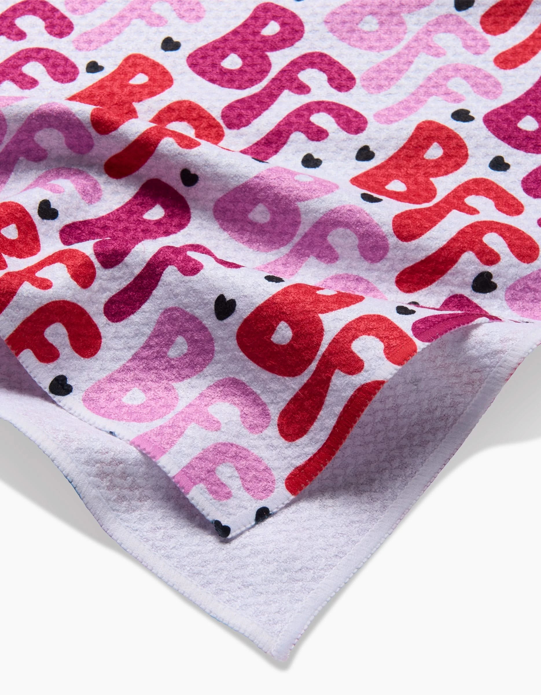 The Best Friends Forever recycled kitchen towel by Hufton Studio features a textured white design with “BF” in red, pink, and purple, plus black hearts. Ultra-absorbent with a folded corner for display.