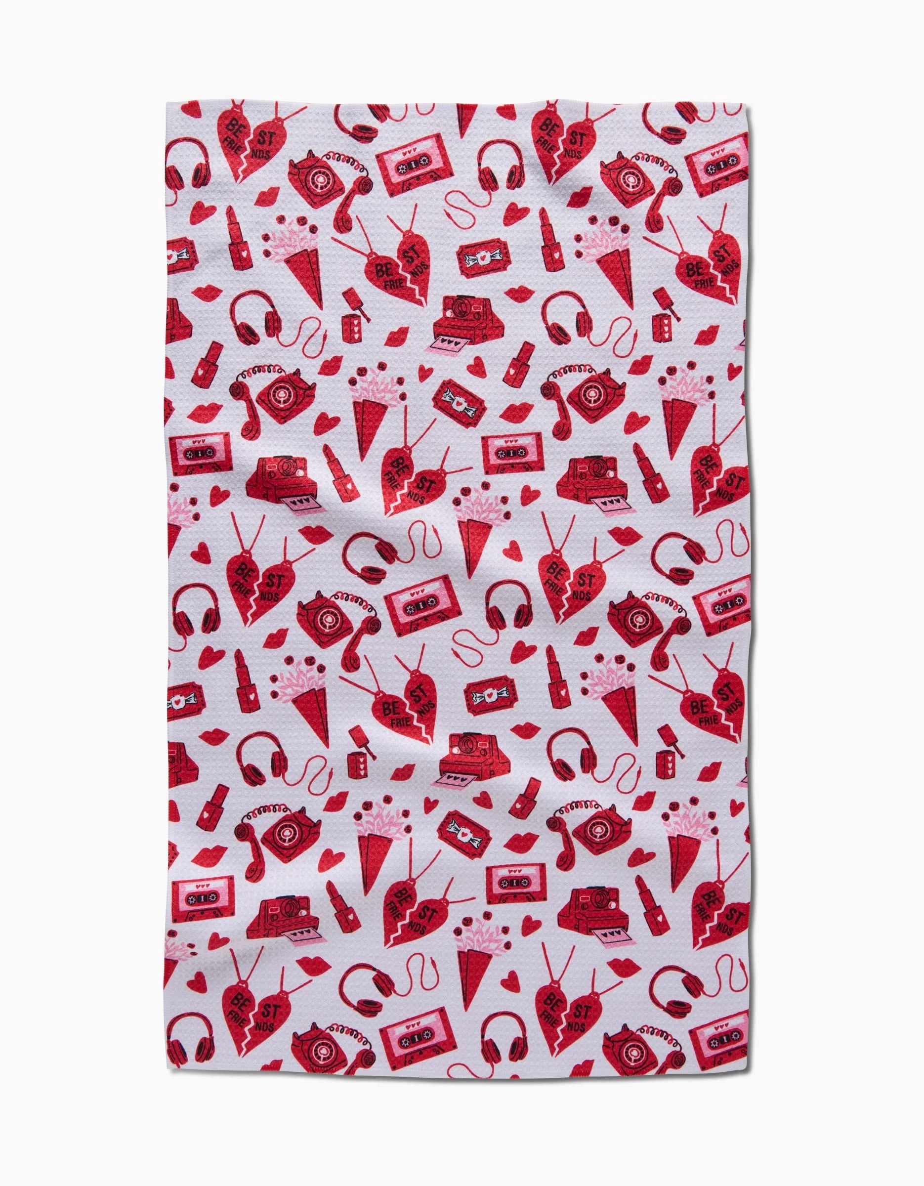 The Best Friends tea towel by Charlie Rowan Designs features a red repeating pattern of cassette tapes, headphones, ice cream cones, eyes, soda bottles, sneakers, lollipops, and roller skates on white—fun and stylish for any kitchen!.