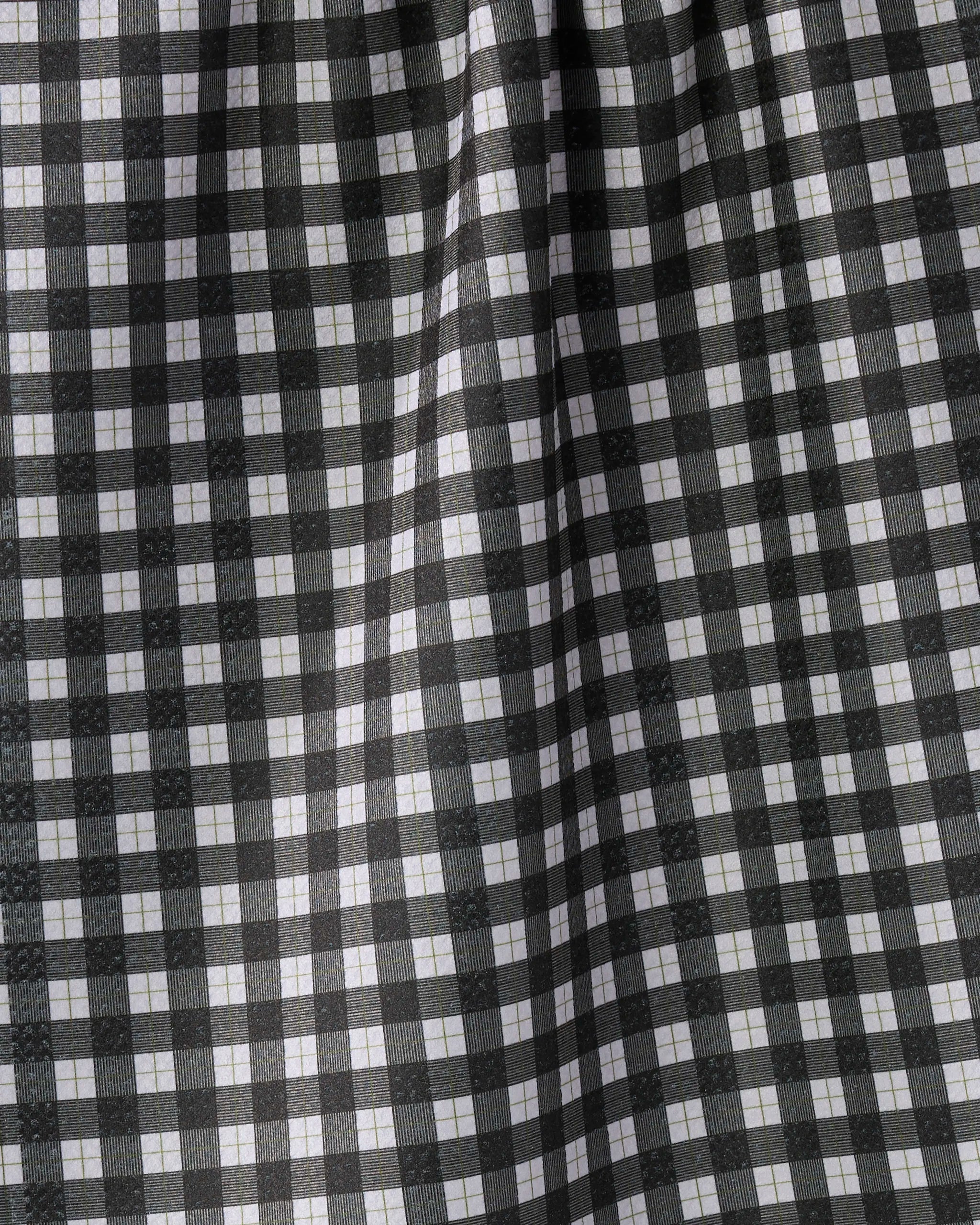 Geometry’s Birchwood tea towel features a black and white gingham checkered pattern with evenly spaced stripes forming small squares, gentle folds, and quick-drying fabric—perfect for any kitchen.