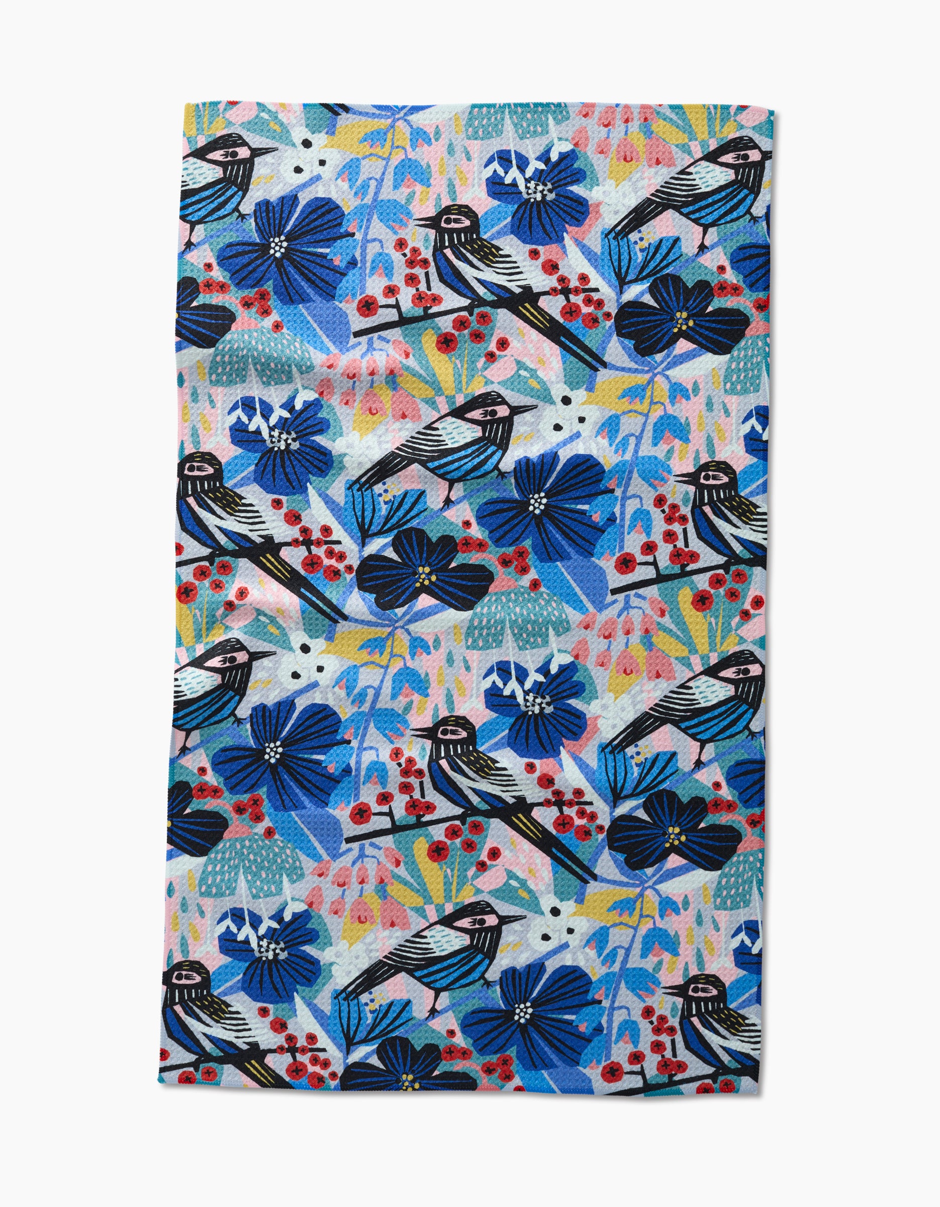 The Birds And Berries tea towel by Masha Volnova features a colorful Geoweave fabric design with blue and purple flowers, red berries, black-and-white birds, and green-yellow foliage.