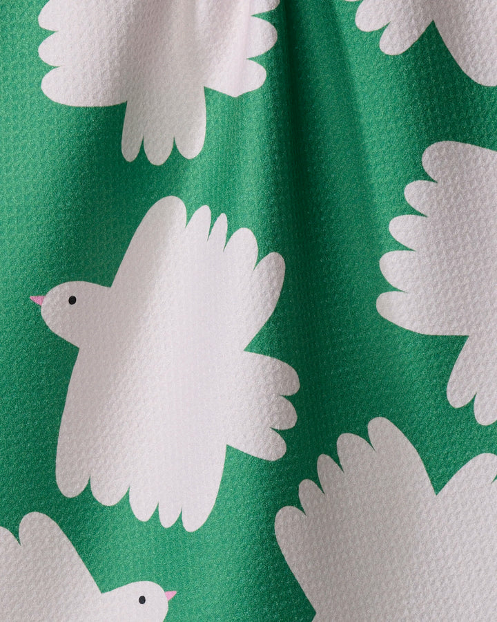 Birds by Jennifer Bouron features white, cartoon-style birds with pink beaks on a textured green tea towel. Its quick-drying fabric offers practicality, while playful designs and gentle folds add a whimsical charm to your kitchen.