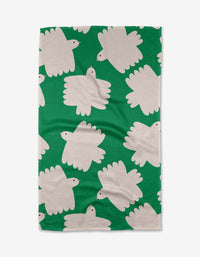 The Birds tea towel by Jennifer Bouron is green, made from recycled materials, and features white abstract bird-like shapes with black eyes in varied directions.