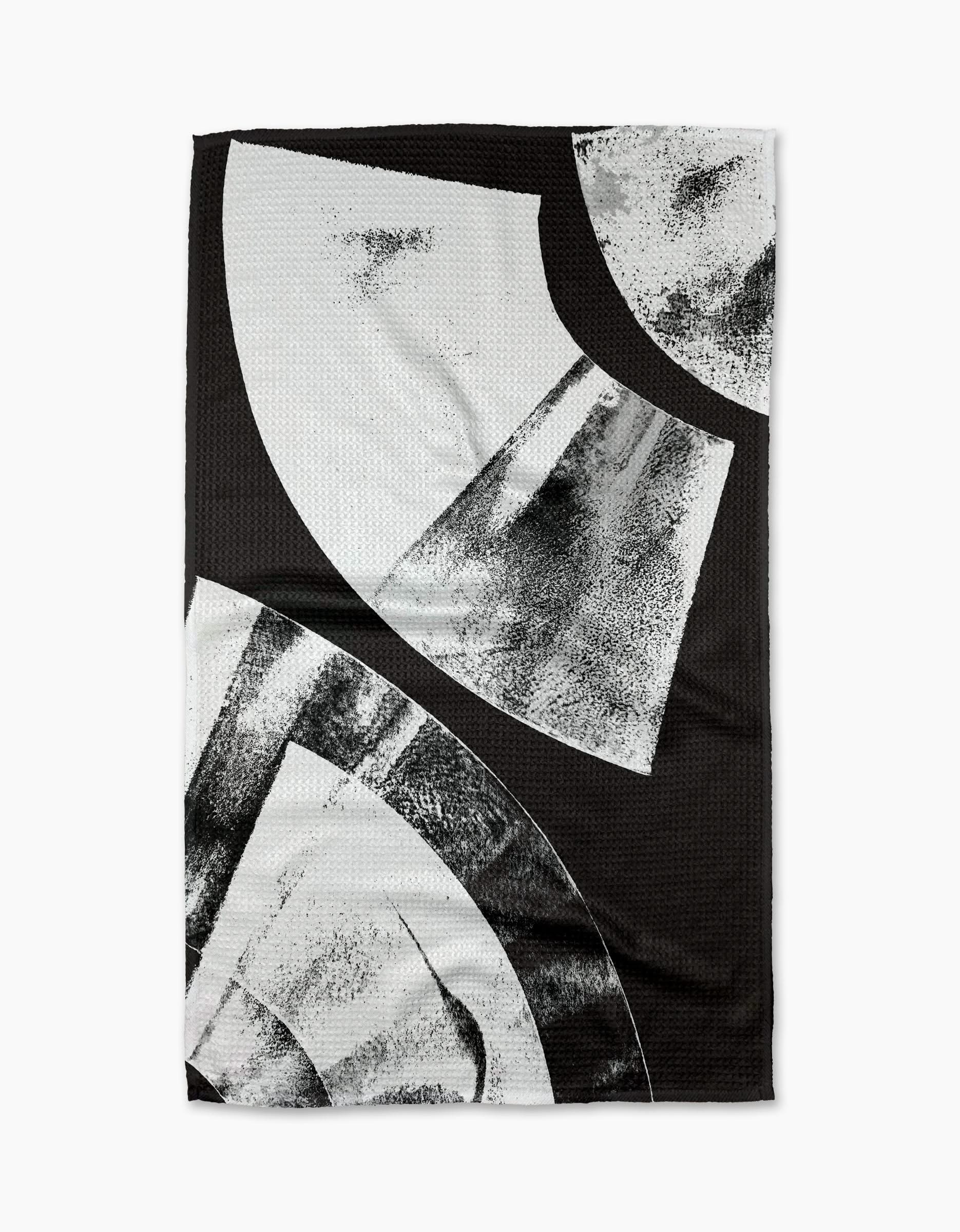 The Skye Walker Black Graphite Shift is a black ultra-absorbent tea towel with bold abstract white and gray geometric shapes and textured brushed patterns, offering a modern, artistic look.