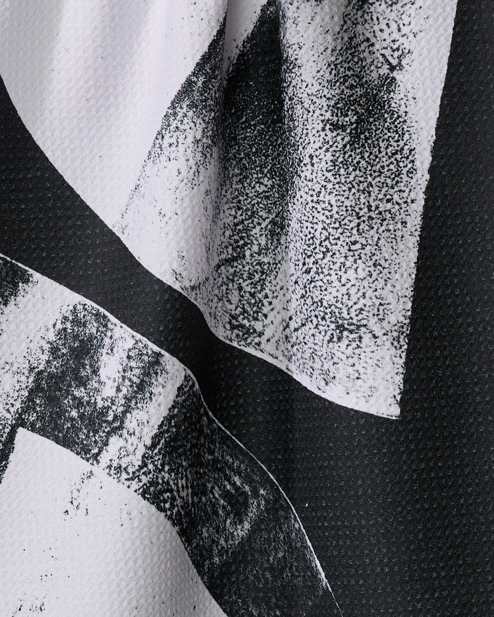 Close-up of Black Graphite Shift by Skye Walker—a black and white kitchen towel with high-contrast abstract dots and curves, crafted from recycled materials.