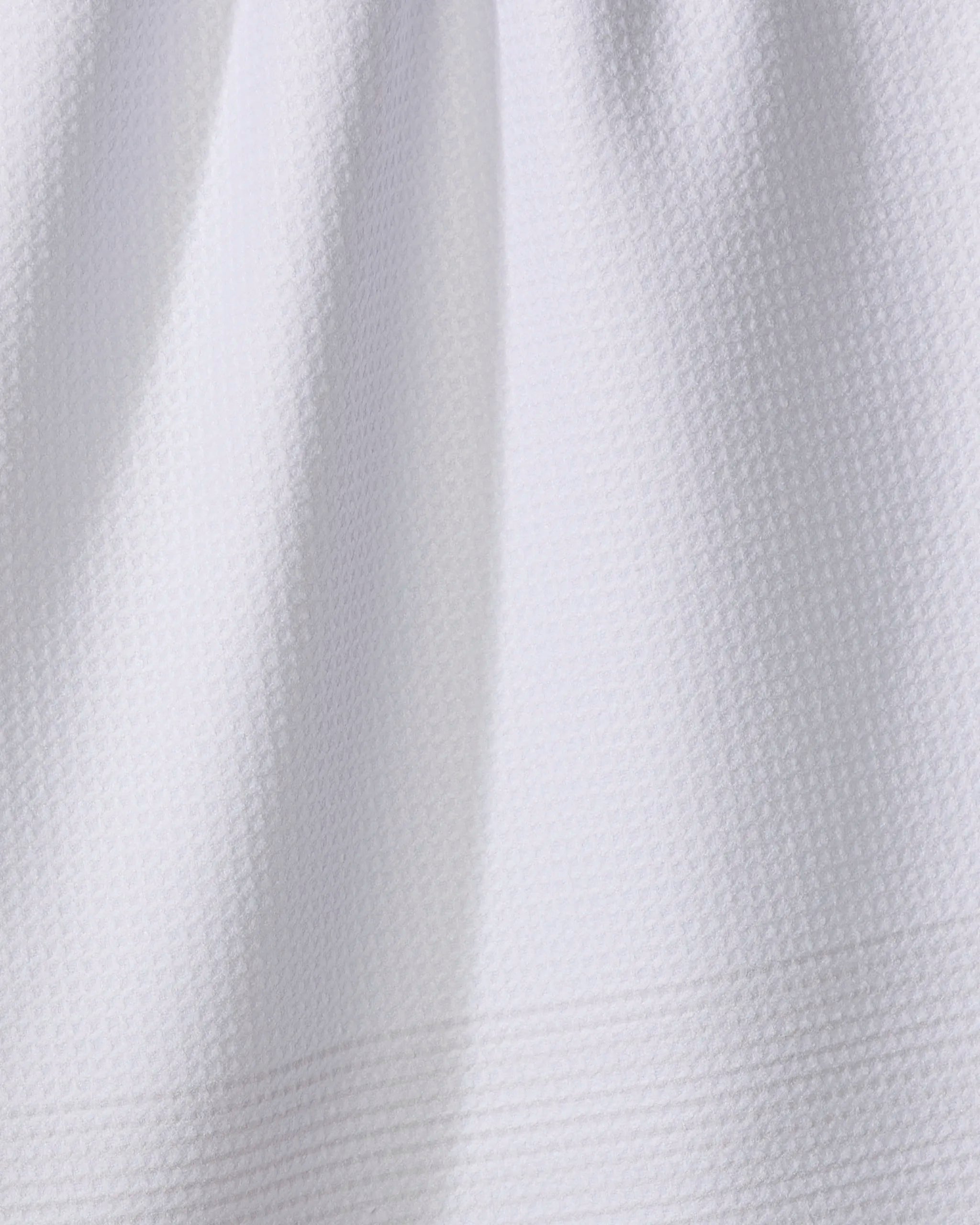 Close-up of The Buy Guide's Blank Space - Beige: an absorbent kitchen towel in white, made from textured fabric with a subtle waffle pattern and gentle folds near the top.