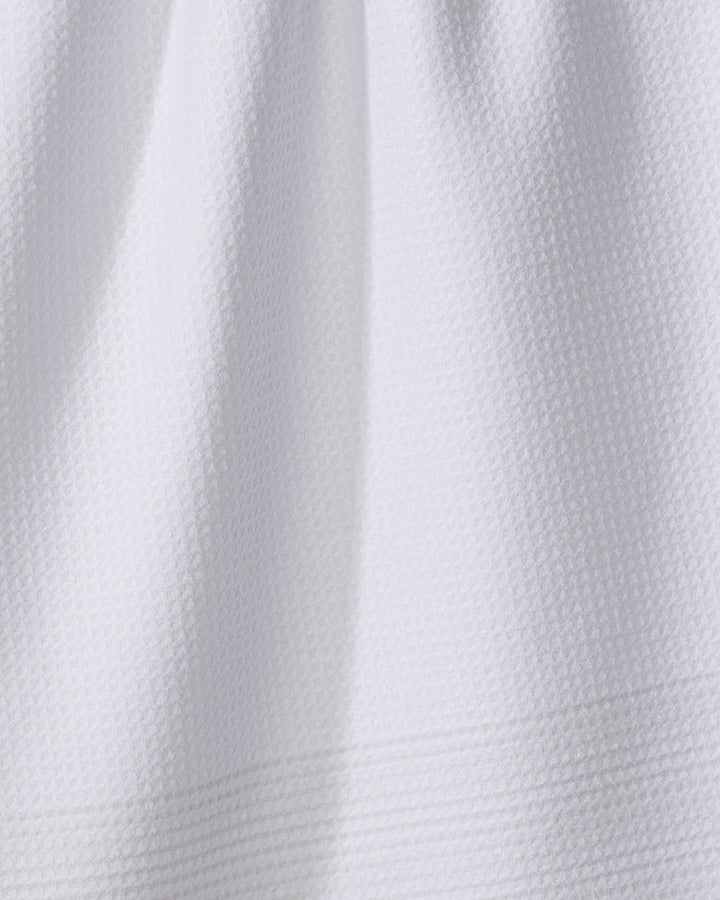 Close-up of The Buy Guide's Blank Space - Beige: an absorbent kitchen towel in white, made from textured fabric with a subtle waffle pattern and gentle folds near the top.