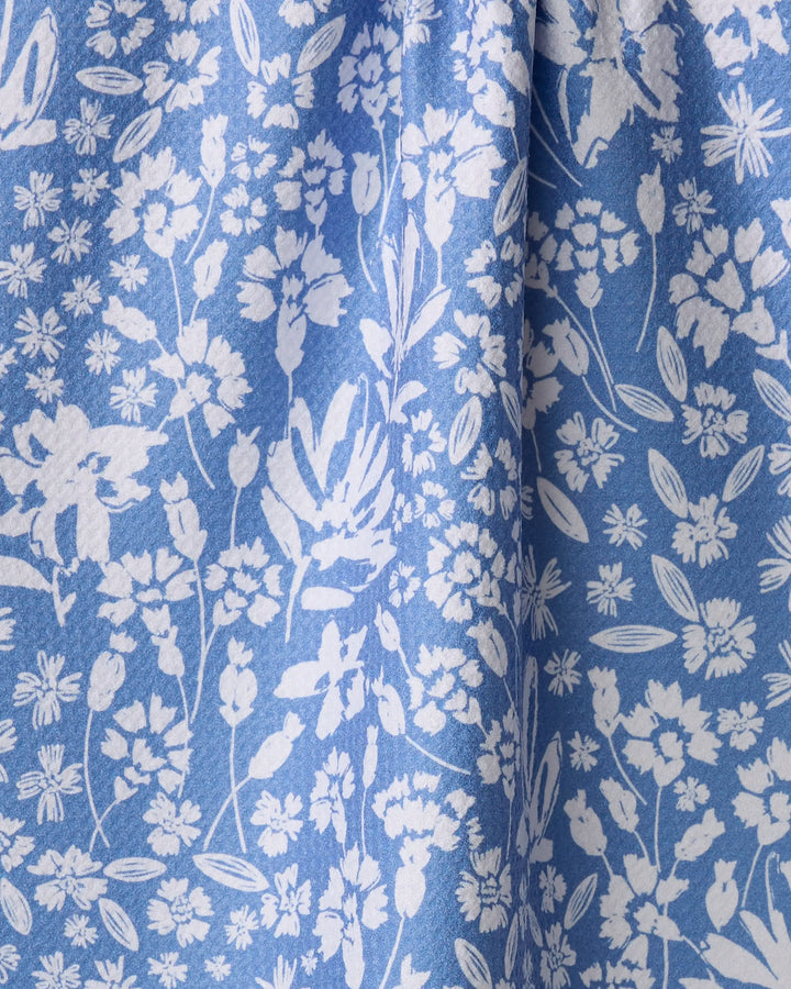 The Bloom Me Over Floral recycled kitchen towel by Hufton Studio features a densely arranged white floral print on blue fabric, adding eco-friendly charm and style to your space.