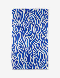 The Blue Willow Wave by Rachel Parker is a rectangular quick-drying towel featuring a bold blue and white wavy abstract pattern on a plain white background.