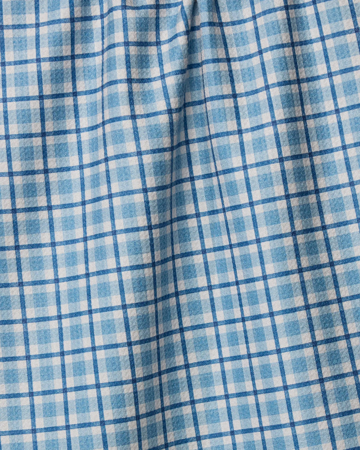 Close-up of the Geometry Bluefield tea towel, featuring a blue and white plaid checkered pattern. Slightly wrinkled, it shows soft folds and texture—making this eco-friendly towel an absorbent choice for your kitchen.