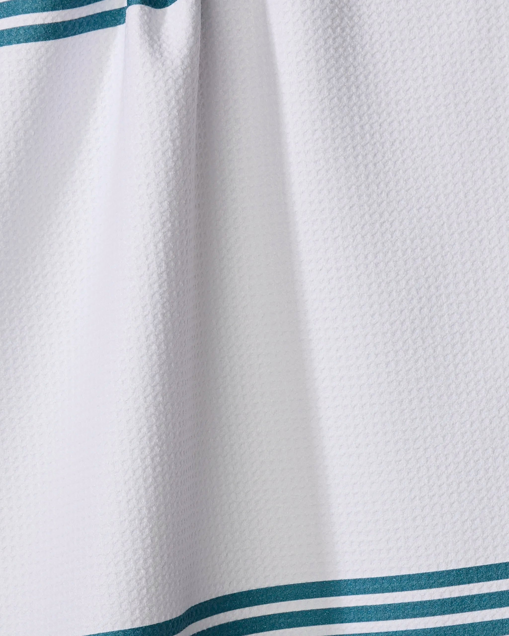 A close-up of The Buy Guide's Bold Blank Space - Emerald: an ultra-absorbent white tea towel featuring teal double stripes along the top and bottom edges for a clean, simple look.