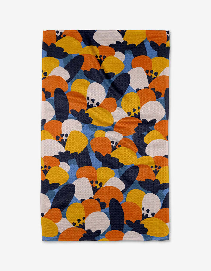 The Bold Petal Bloom tea towel by Claire Iglesias features an abstract pattern in orange, yellow, navy blue, and white with curved shapes and circles on ultra-absorbent Geoweave fabric.