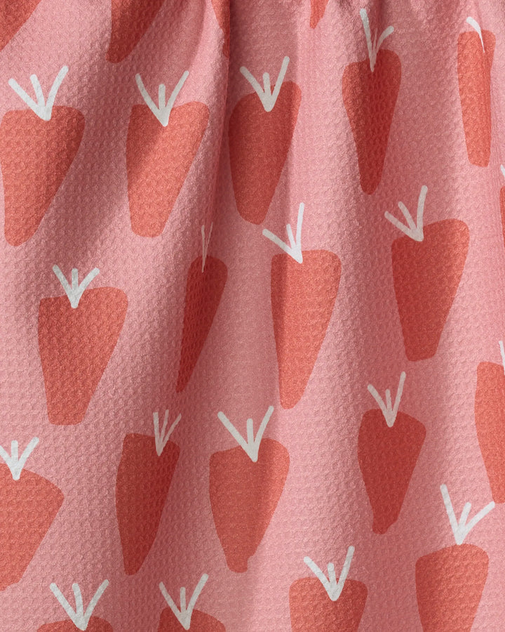 Bountiful by Lizzie Clark is an ultra-absorbent kitchen towel with a textured pink fabric, featuring a repeating pattern of stylized red strawberries with white stems—perfect for everyday use.